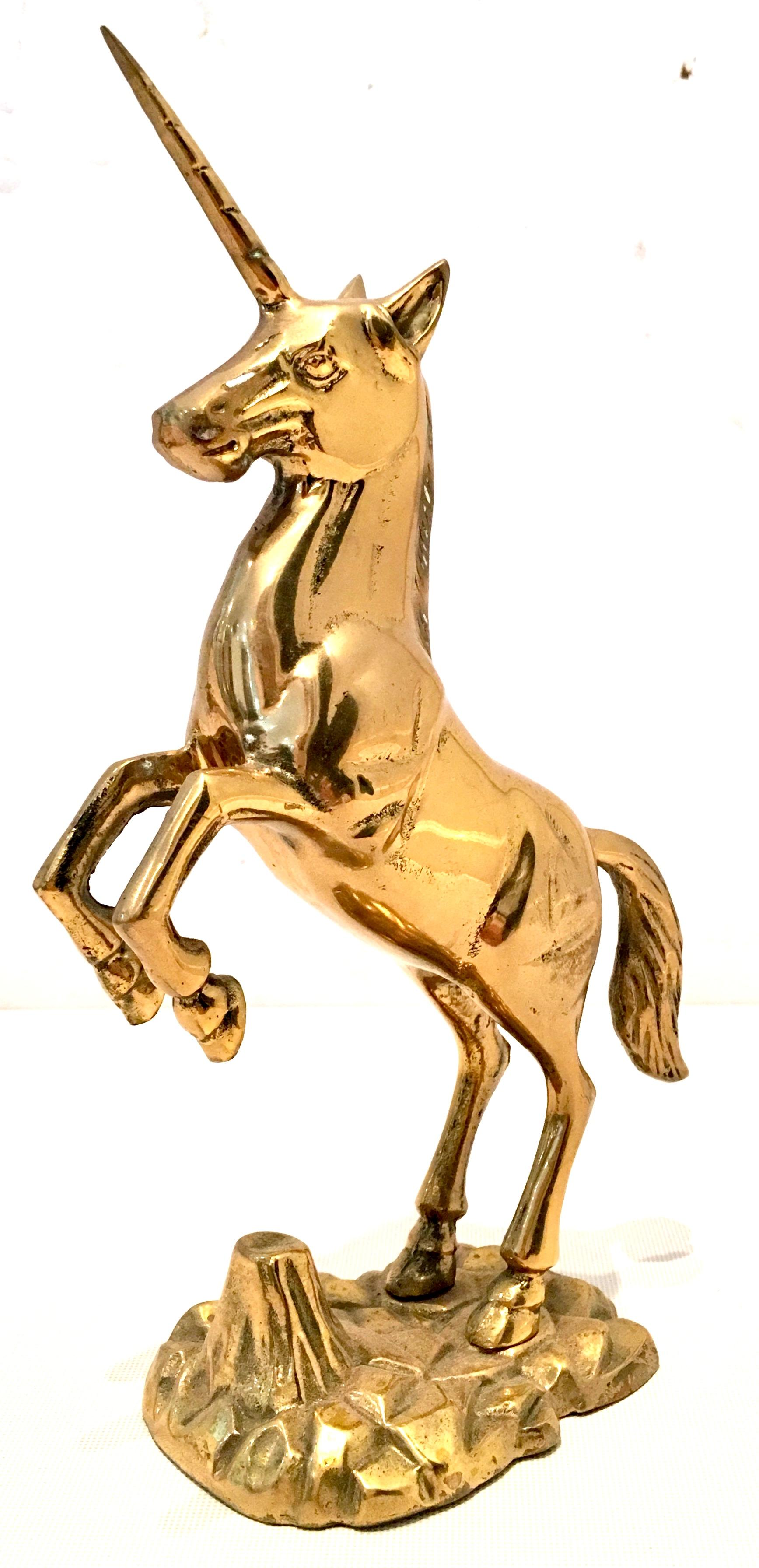 Mid 20th-Century solid brass unicorn sculpture. This heavy weighted polished solid brass unicorn sculpture is mounted on abstract faux solid brass rock plateau.