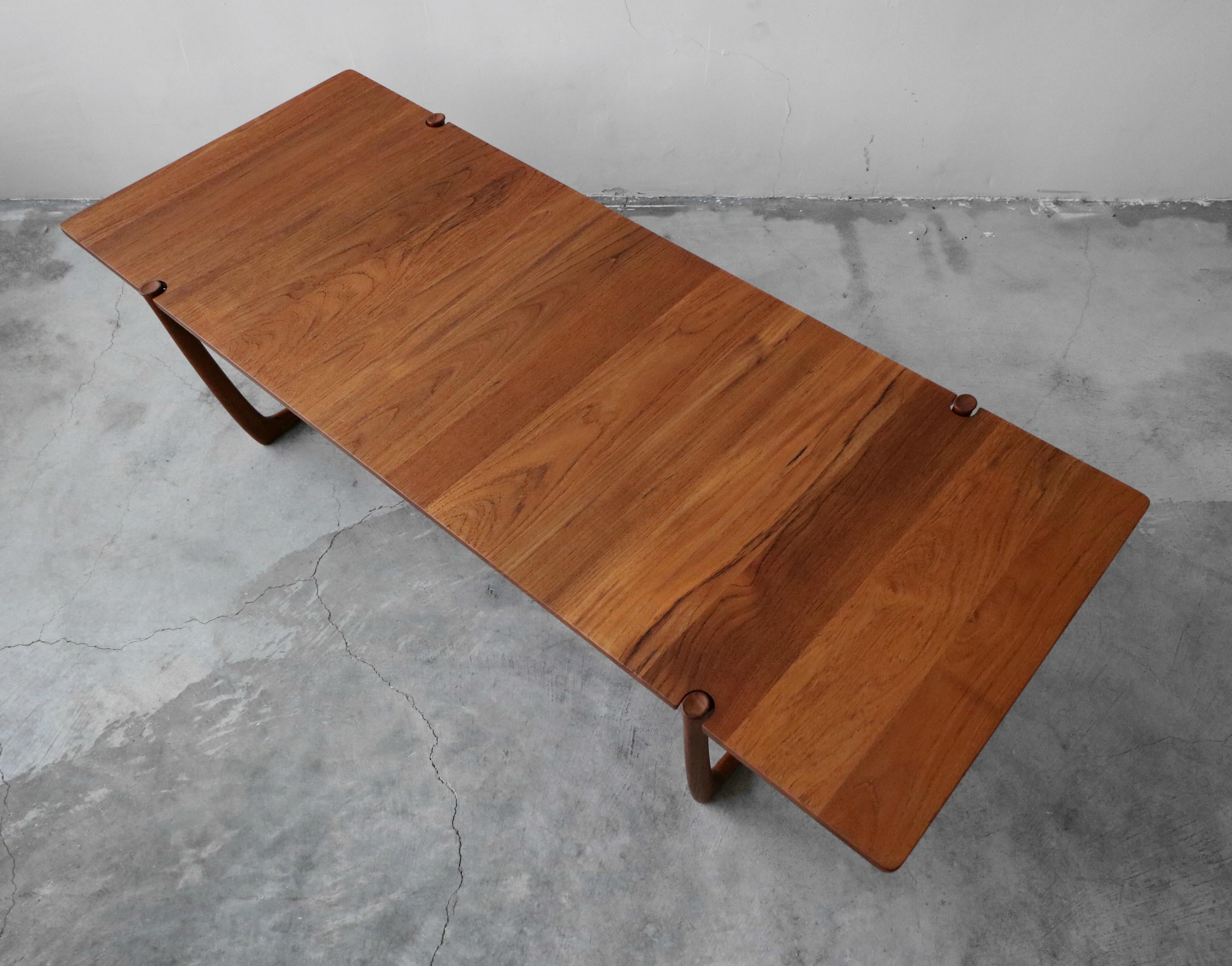 Large solid teak Danish coffee table by Peter Hvidt & Orla Mølgaard-Nielsen for France & Son, distributed by John Stuart. This coffee table is a great example of fine Danish craftsmanship. 2 beautifully detailed, sleigh style legs are notched in to