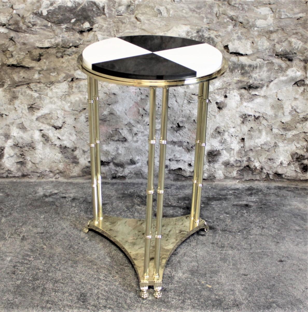 This midcentury era heavy solid brass pedestal side table with a marble top has no maker's marks or labels, but presumed to have been made in the United States in circa 1970 in an Empire Revival style. The base is solid brass with a circular raised