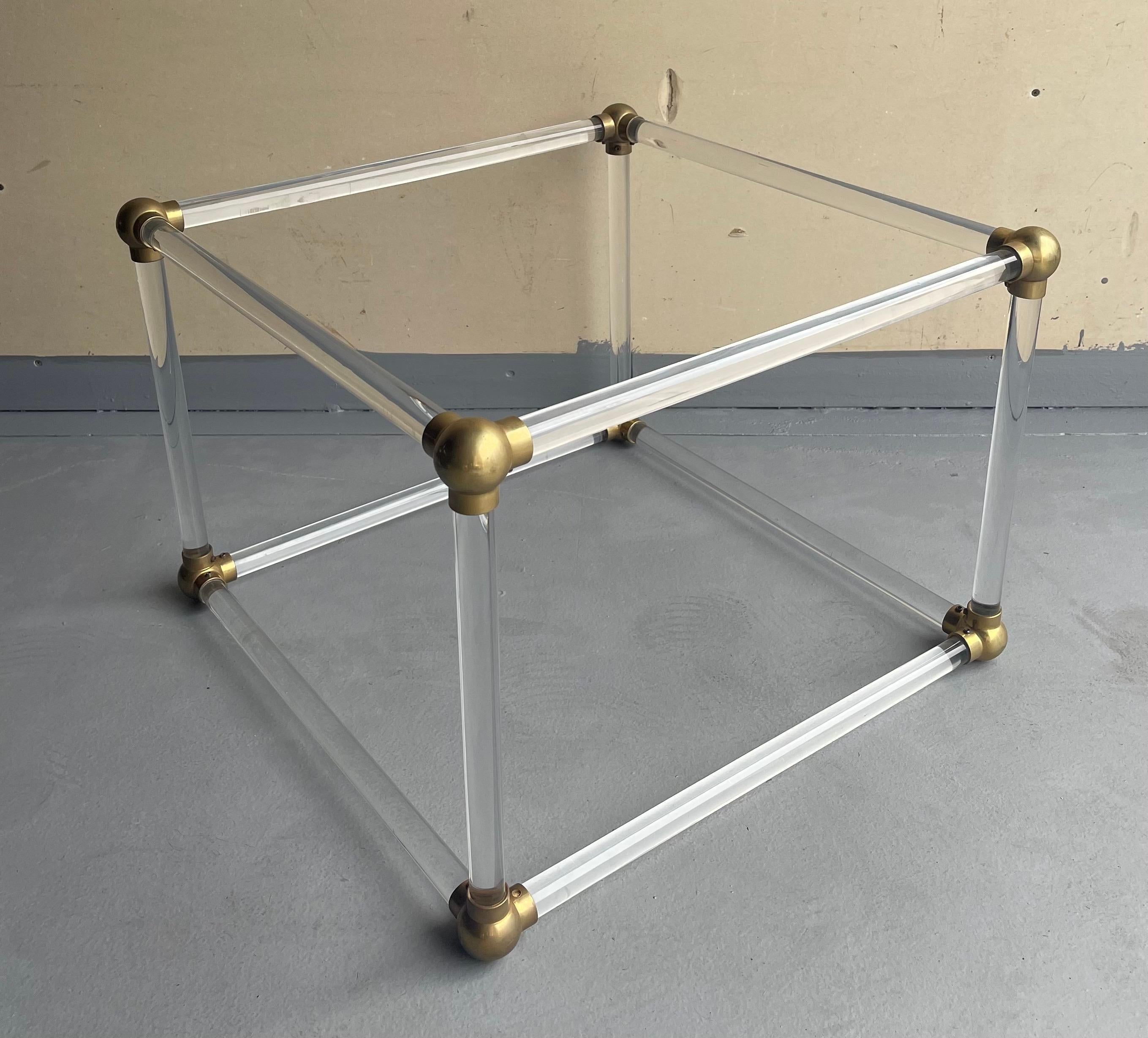 Unique mid-century lucite cube and brass connector coffee table base in the style of Charles Hollis Jones, circa 1970s. The tubular lucite poles and brass connectors have been freshly polished and it makes a very unique and stunning piece. It can be