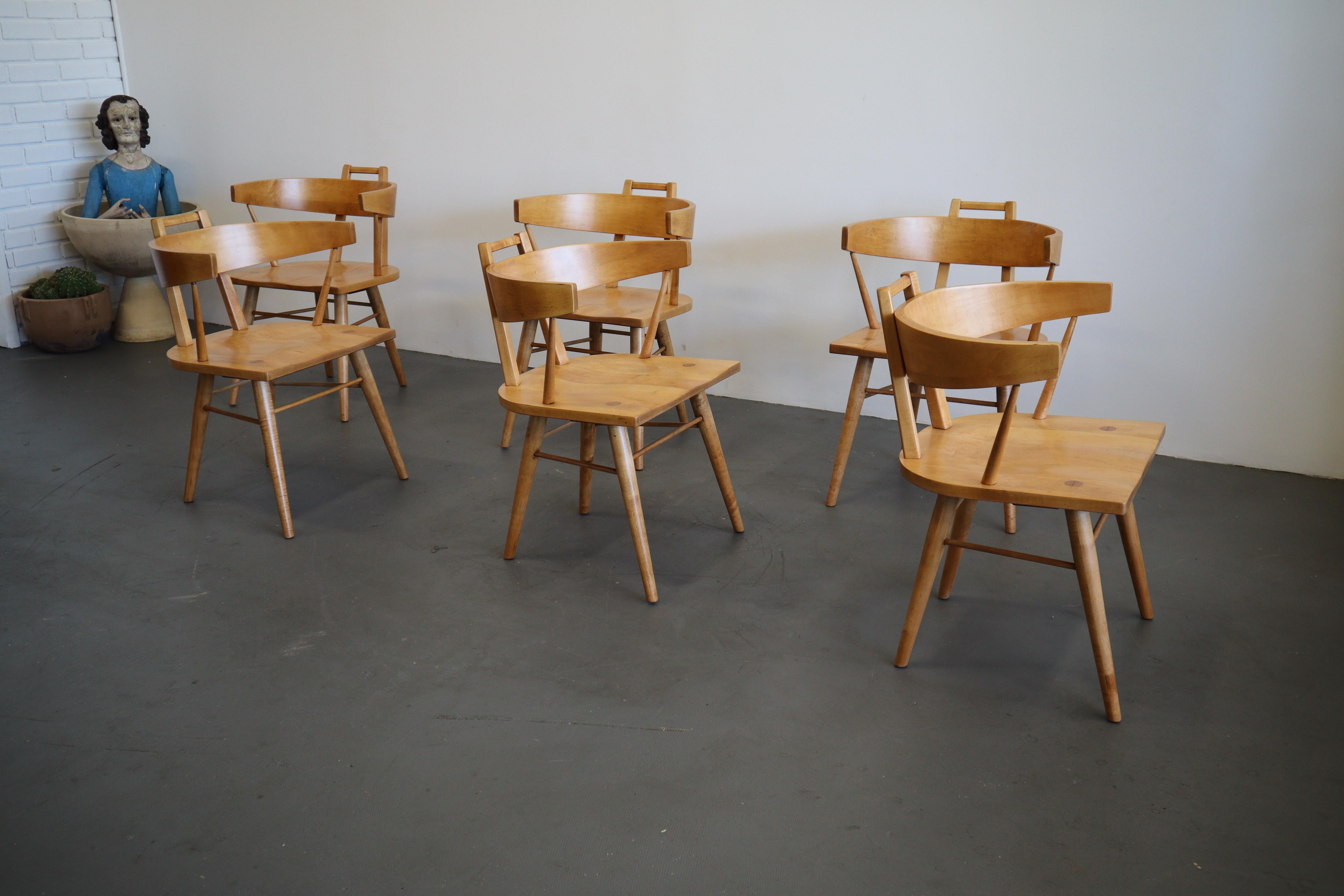 Stunning set of sculptural solid maple dining chairs. The character of the exposed joinery on the seats are details of true quality and craftsmanship. They have all been recently refinished and are ready to enjoy another lifetime of use.