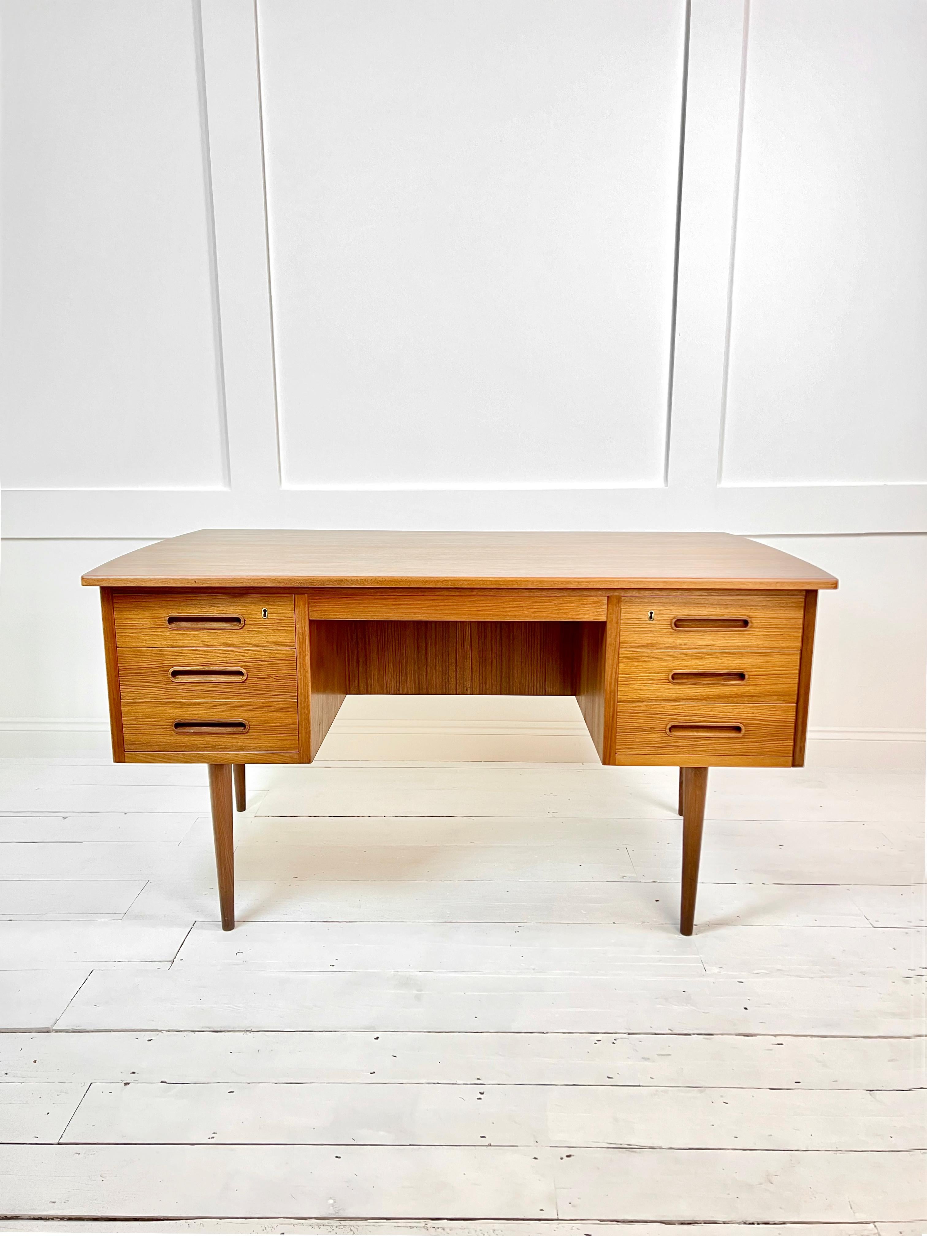 This stunning Mid Century Solid Teak & Veneer Surface Desk. Danish in Design, Boomerang shape model, slightly curved top to front and back edges with a large niche at the back for storage of books. It is composed of 6 drawers with inlaid handles in