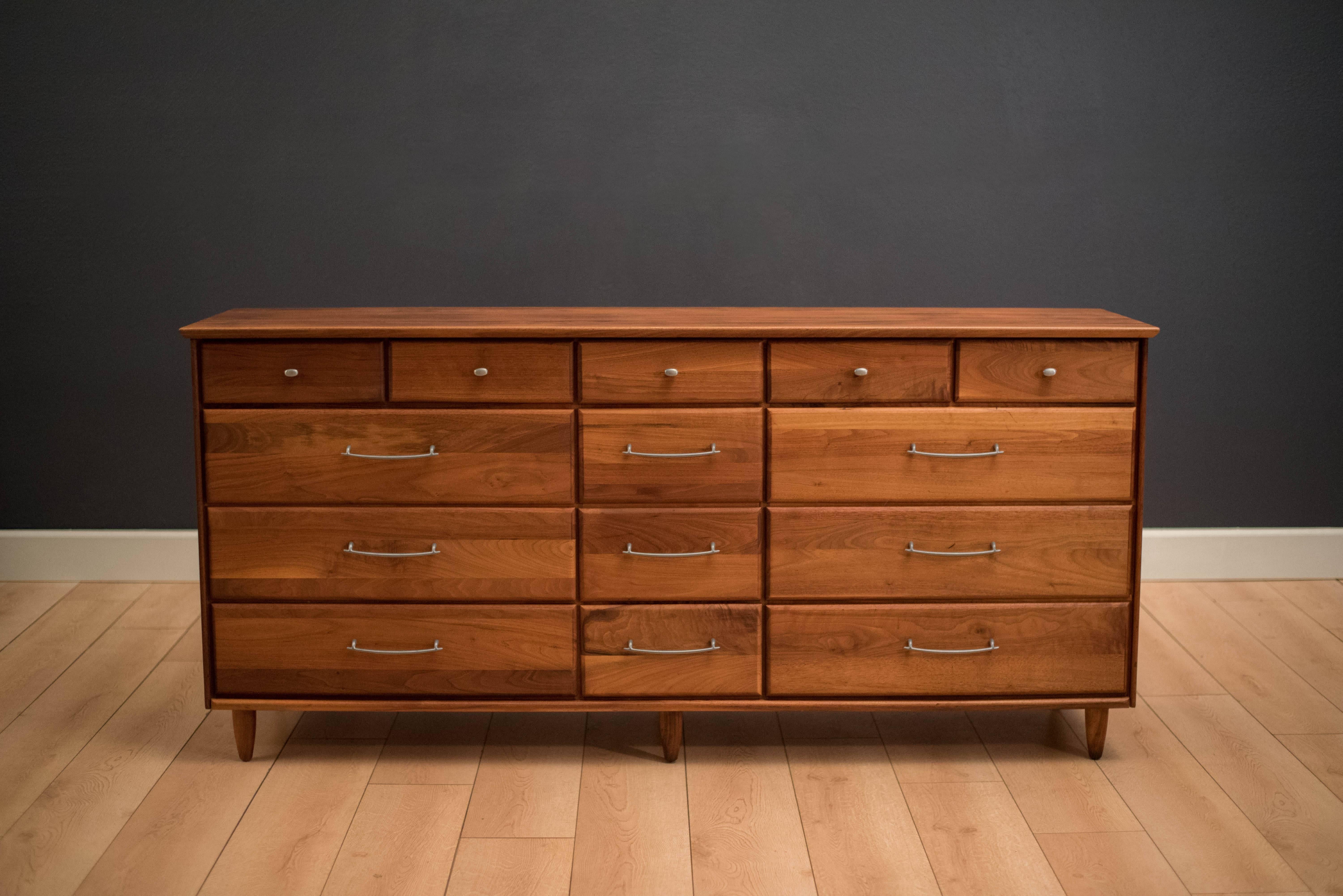 Mid-century prelude dresser for ACE-HI Furniture in solid planked walnut. This piece features fourteen storage drawers accessorized with pewter pulls.