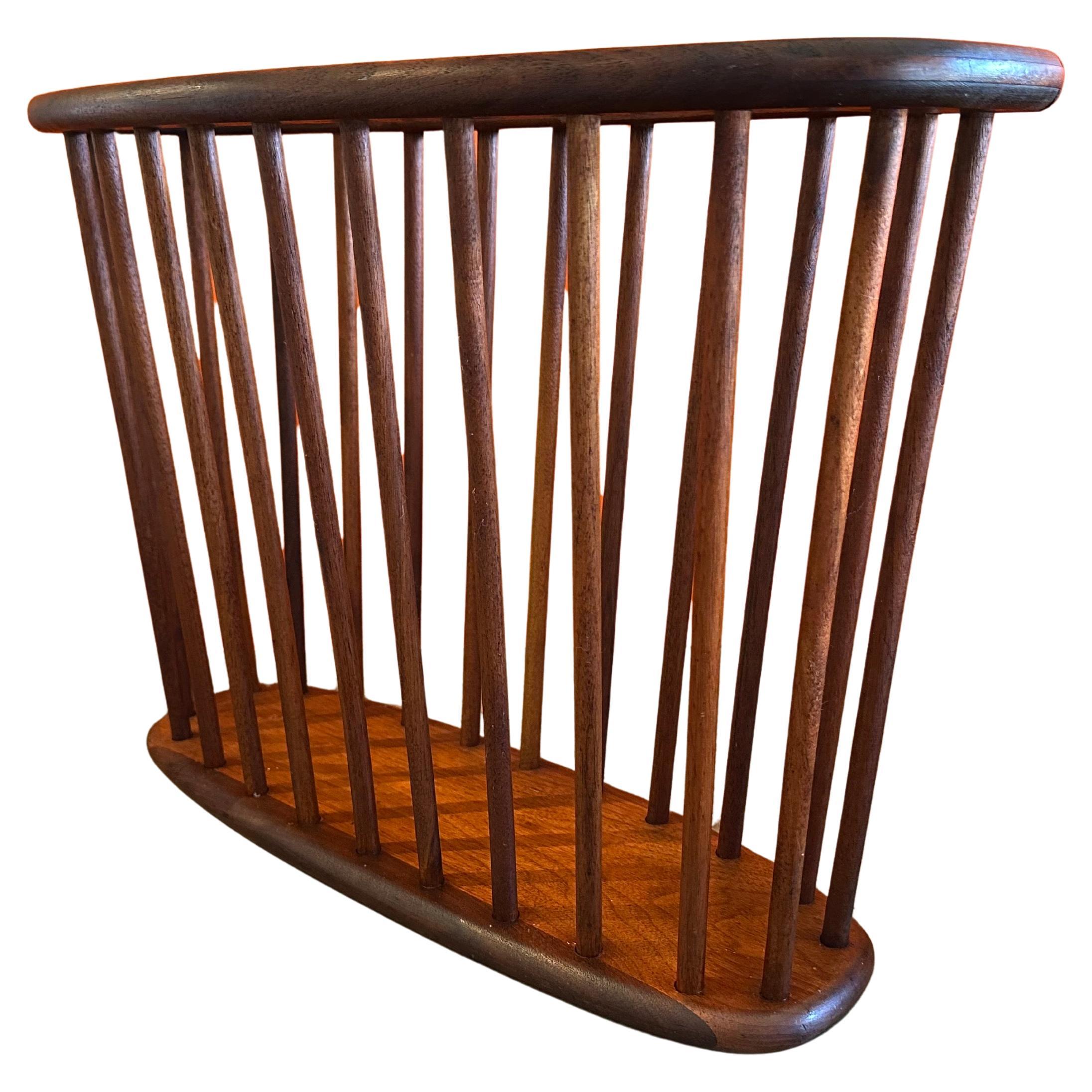 Este revistero de nogal macizo de mediados de siglo, obra de Arthur Umanoff, circa 1960, ofrece tanto estilo como funcionalidad. La pieza está en muy buen estado vintage y mide aproximadamente 21