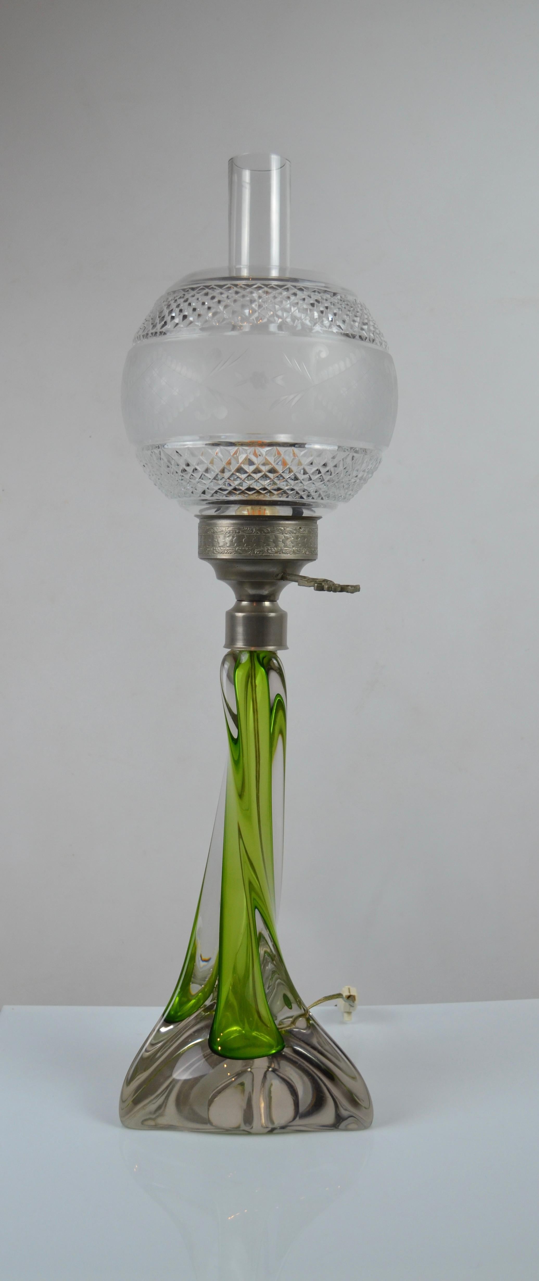Grande lampe de table sculpturale datant des années 1950.
La base est en verre soufflé avec un effet Sommerso, avec un cœur vert entouré de verre transparent. Cette technique crée de la profondeur et de la fluidité, encore soulignées par l'élégante