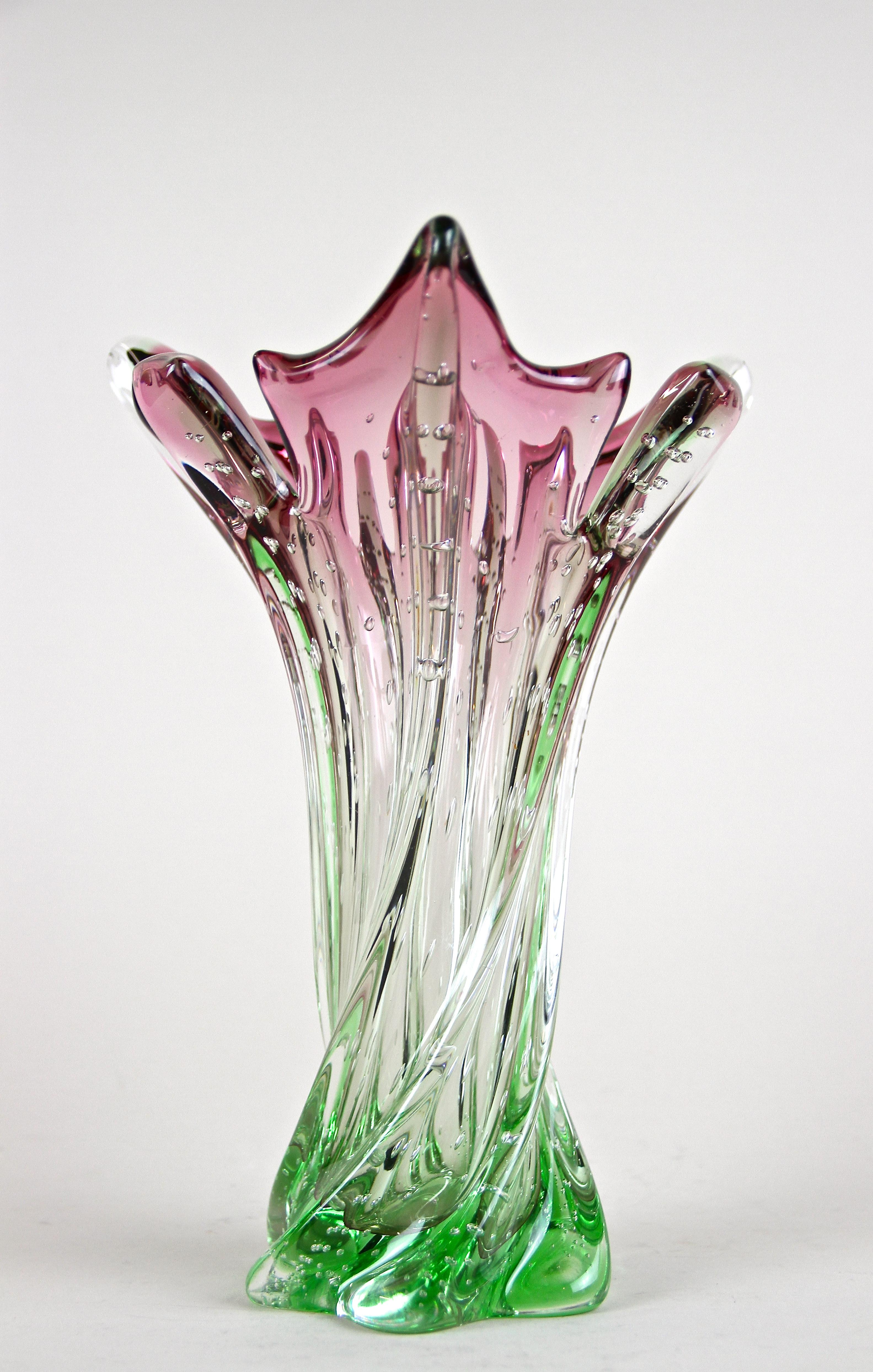 Highly decorative mid century Murano Glass Vase from the renown workshops in Italy around 1960/70. A fantastic shaped, mid-sized vase with twisted body combined with a lovely coloration from pink tones down to a bright green on the base. An