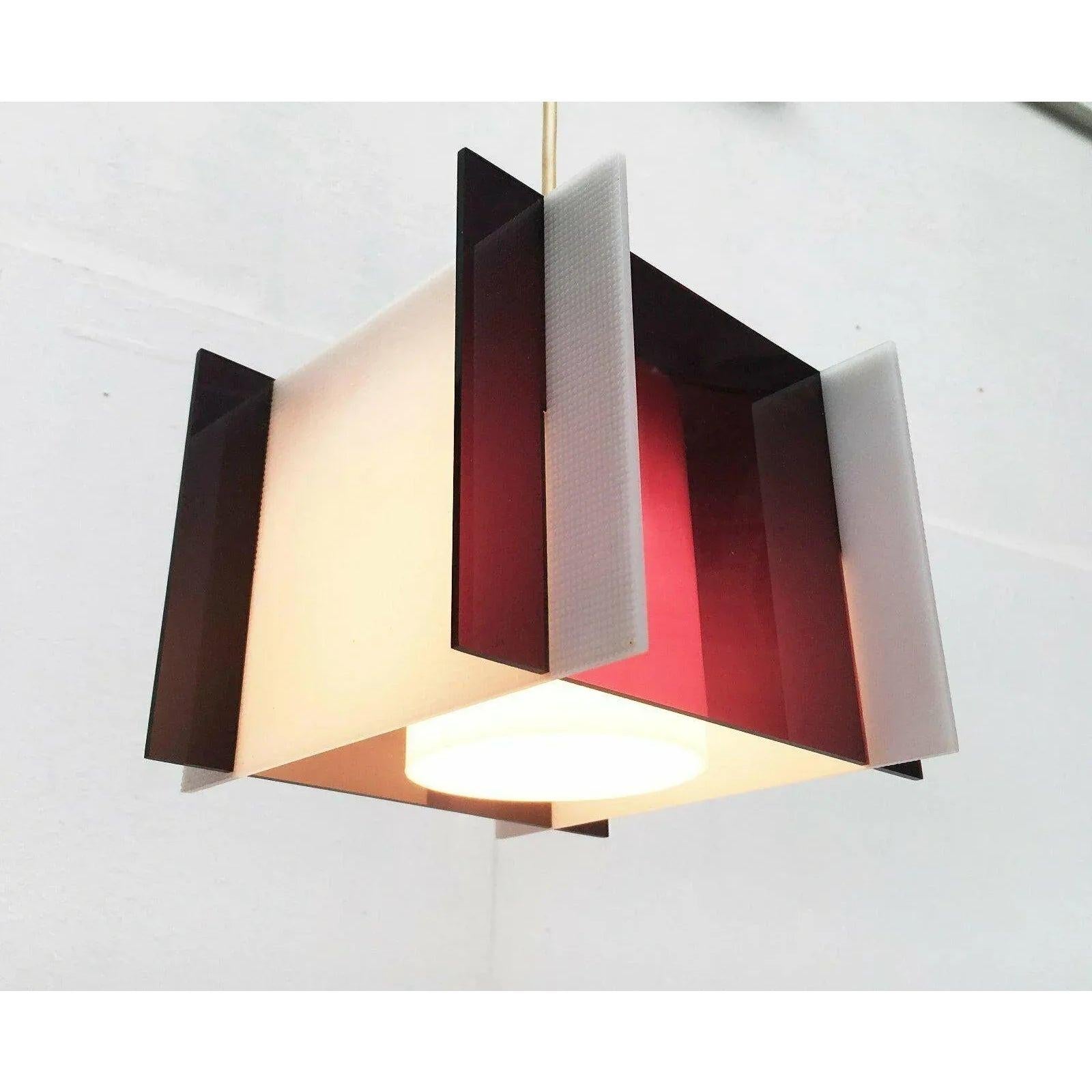 Lampada a sospensione di metà secolo in vetro acrilico.

Il linguaggio del design è molto semplice e senza tempo. La lampada è composta da dischi che vengono inseriti l'uno nell'altro con proiezioni visibili. Il contrasto tra il colore bicolore e la