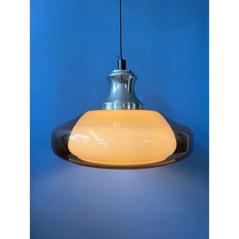 A very special space age pendant light by the Dutch brand Herda. The lamps consists of an acrylic orange/copper coloured outer shade and a white inner shade. The lamp requires one E27 lightbulb and currently has an EU-plug.

Dimensions:
ø: 42