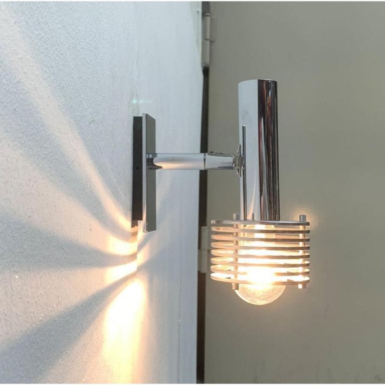 Applique da parete Space AGE in cromo.

Un dettaglio sorprendente di questo apparecchio è lo schermo del riflettore che è dissolto in lamelle. Queste danno l'aspetto libero alle lampadine e allo stesso tempo fanno da scoat. La testa del radiatore