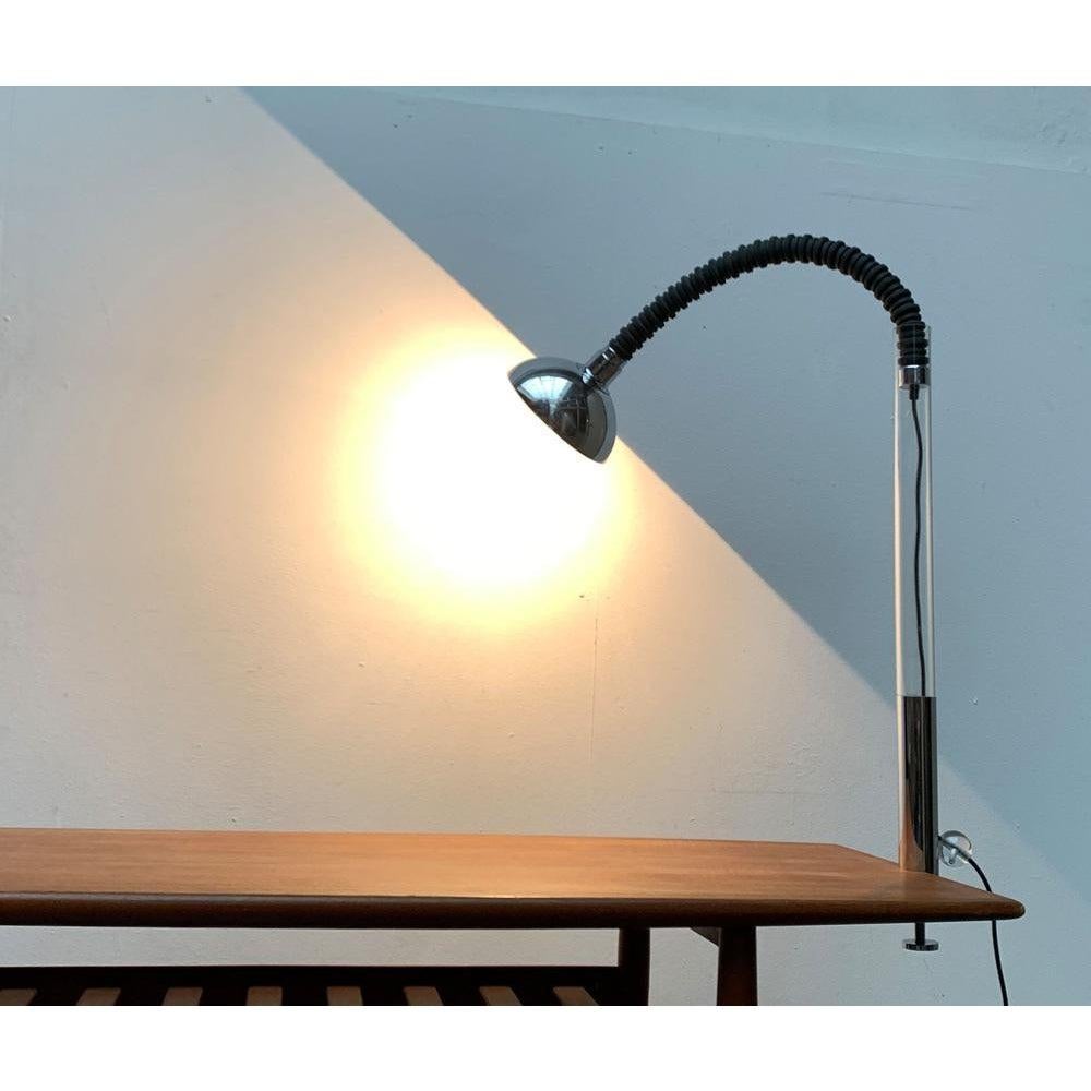 Rare Space Age table lamp of special materiality.

This draft impresses with the unconventional use of materials from other areas of application. In particular, the use of a rubber hose is to be mentioned as a shaft. At the top of the lamp there is