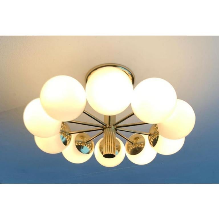 Imposant plafonnier ou applique murale de Kaiser shine.

La surface brillante en laiton confère à ce modèle un aspect de haute qualité. La tige mince se transforme en une plaque en forme de trompette. Les boules de diffusion en verre blanc révisé
