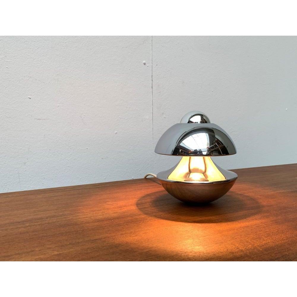 Rare table lamp from Kaiser after a design by Klaus Hempel from the 1970s.

Small but impressive table lamp in a striking coloring in chrome. The lamp is predestined for a head -reflected lamp. This fits perfectly into the upper opening of the lamp,