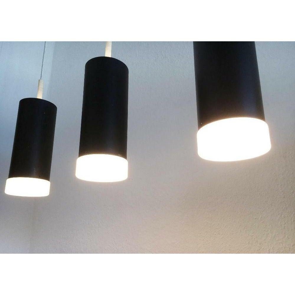 3 pendoli su una guida monta del noto produttore Staff Leuchten, Germania.

Forma semplice e combinazione di colori bianco e nero. I singoli pendoli hanno una semplice forma cilindrica alla cui estremità si trova un diffusore in vetro opalino. Il
