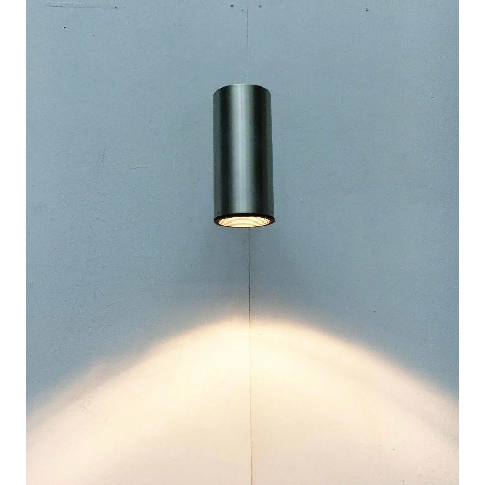 Appliques ou plafonniers simples de l'ère spatiale du personnel.

La lampe se compose principalement d'un grand cylindre en aluminium ouvert d'un côté. Le cylindre se trouve au bout d'un arbre noir et peut être tourné et incliné grâce à une