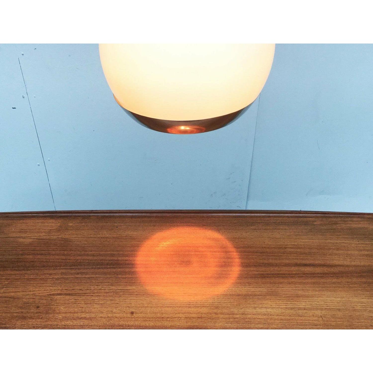 Rara lampada a sospensione a sfera dell'era spaziale con diverse modalità di accensione.

La parte superiore della lampada è costituita da una sfera di plastica traslucida che può essere illuminata dall'interno. La parte inferiore della lampada è