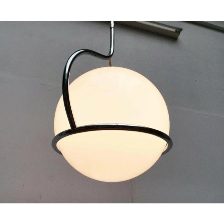 Elegante lampada a sospensione dell'era spaziale di origine italiana.

Un design imponente ma semplice. Una grande sfera di vetro è racchiusa in un anello dalla curva elegante realizzato in tubolare d'acciaio cromato. La sfera di vetro funge da