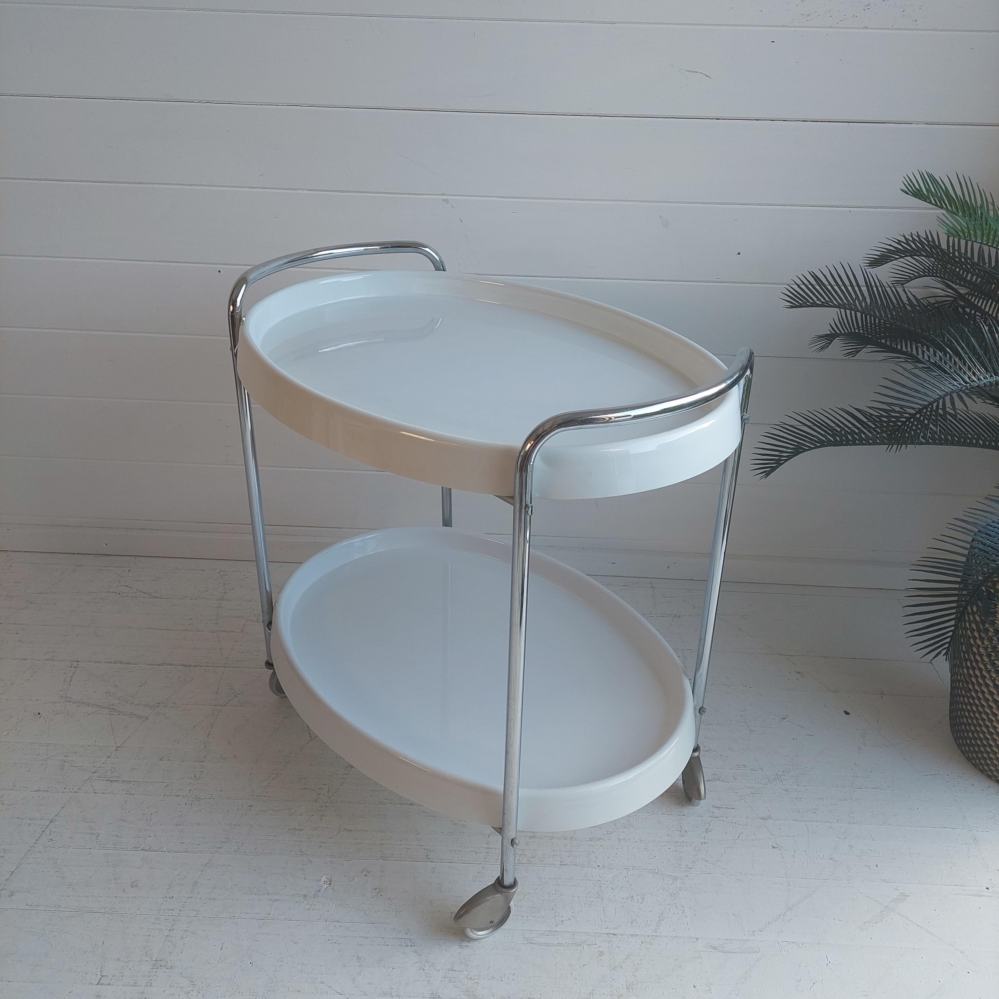 Exclusive midcentury white plastic & chrome metal oval bar cart. 
This very rare piece was produced in Italy in the 1950/60s. 

The presented Space Age vintage bar cart from the 1950/60s shows a chromed tube steel frame and four wheels for