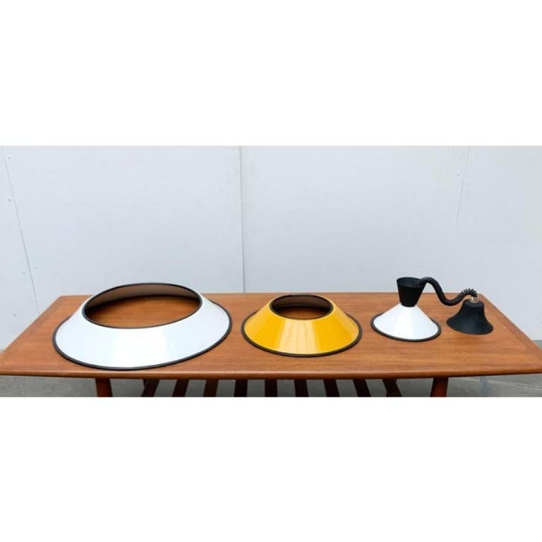 Pendolo ferroviario italiano con ombrelli impilati.
 
 Un design minimalista e funzionale. Lo schermo della lampada è costituito da una combinazione di tre elementi che insieme danno vita a un ombrello conico. I singoli ombrelli giacciono sciolti.