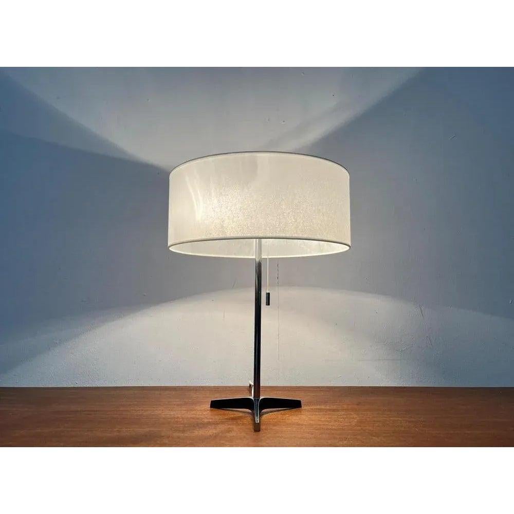Rare Mid-Century Tripod table lamp.

A minimalist design with a special foot. The chrome -colored shaft ends in a simple tripod foot. The top of the foot is polished. The pages are discontinued in black. The cable occurs on the back at the bottom.