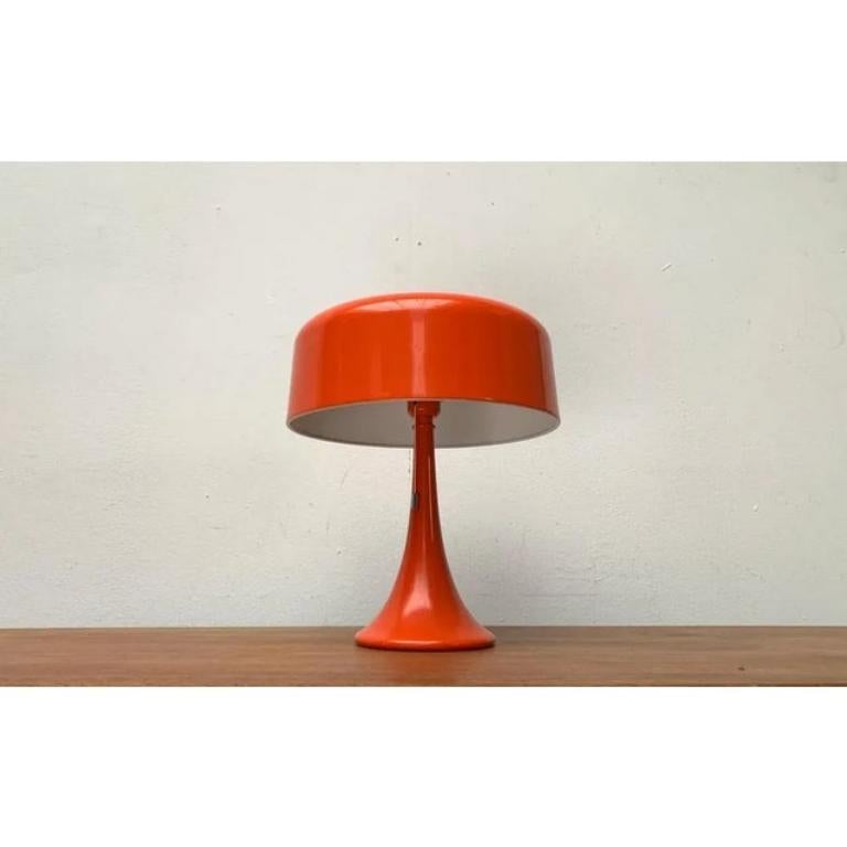 Rare lampe à poser en forme de champignon orange du milieu du siècle dernier.

Un design minimaliste dans une couleur frappante. Le parapluie simple est en forme de tambour et se ferme avec un large rayon au sommet. Elle est placée sur un cadre en