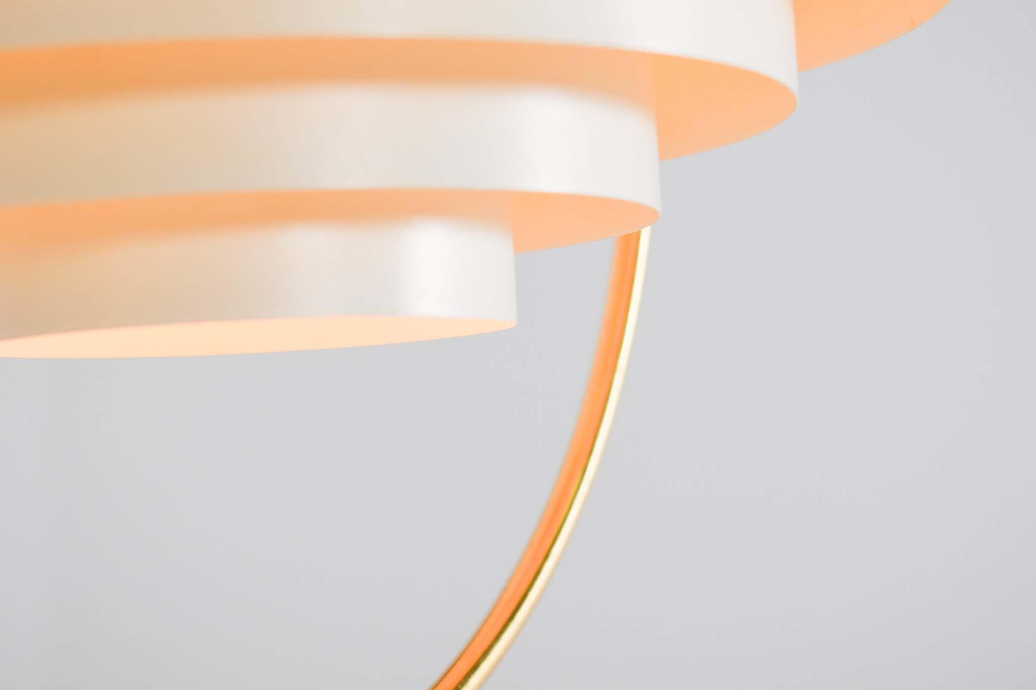Luce a sospensione dell'era spaziale degli anni '70. Questa lampada a sospensione è composta da un mezzo globo in alluminio con una griglia in metallo bianco e circondato da un cerchio in metallo dorato. Progettato e prodotto in Danimarca nel 1970