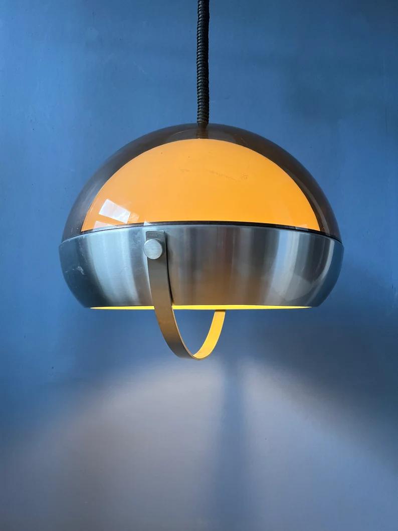 A unique Lakro space age pendant lamp with double acrylic glass shade. The lamp has one clear outer shade and a white inner shade. The two 'domes' rest on the aluminium frame underneath. The height of the lamp can be adjusted with the rise-and-fall