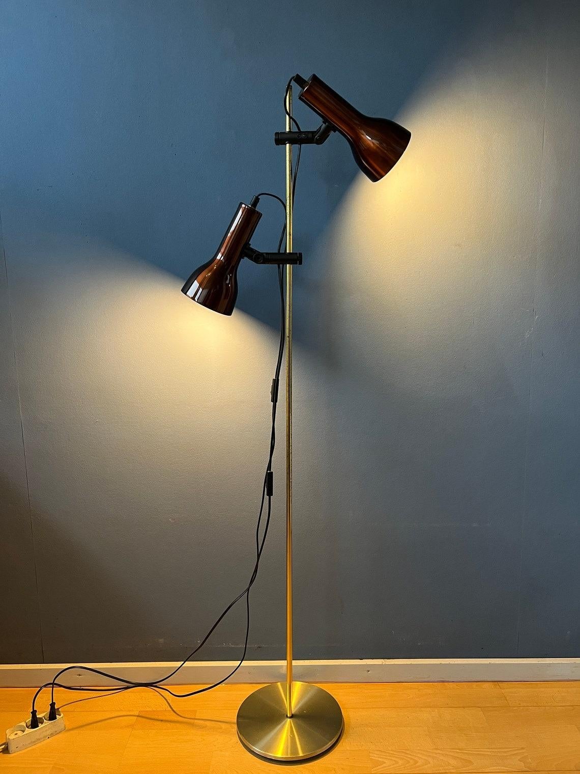 A space age floor lamp with two bourdeaux red spots. The spots can be turned in any direction desirable and move up and down the base. The spots can be switched on simultaneously or separately. The lamp requires two E27/26 lightbulbs.

Additional