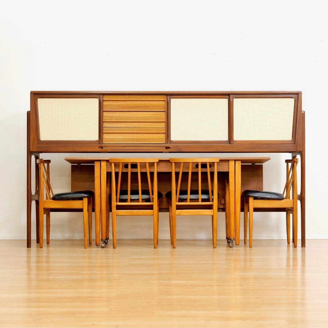This vintage mid-century dining suite was made in the U.K. by Elliots of Newbury circa mid 1960's. It's a very clever space saving design that can be used in a variety of ways, depending on your space and circumstances. The dining table has a drop