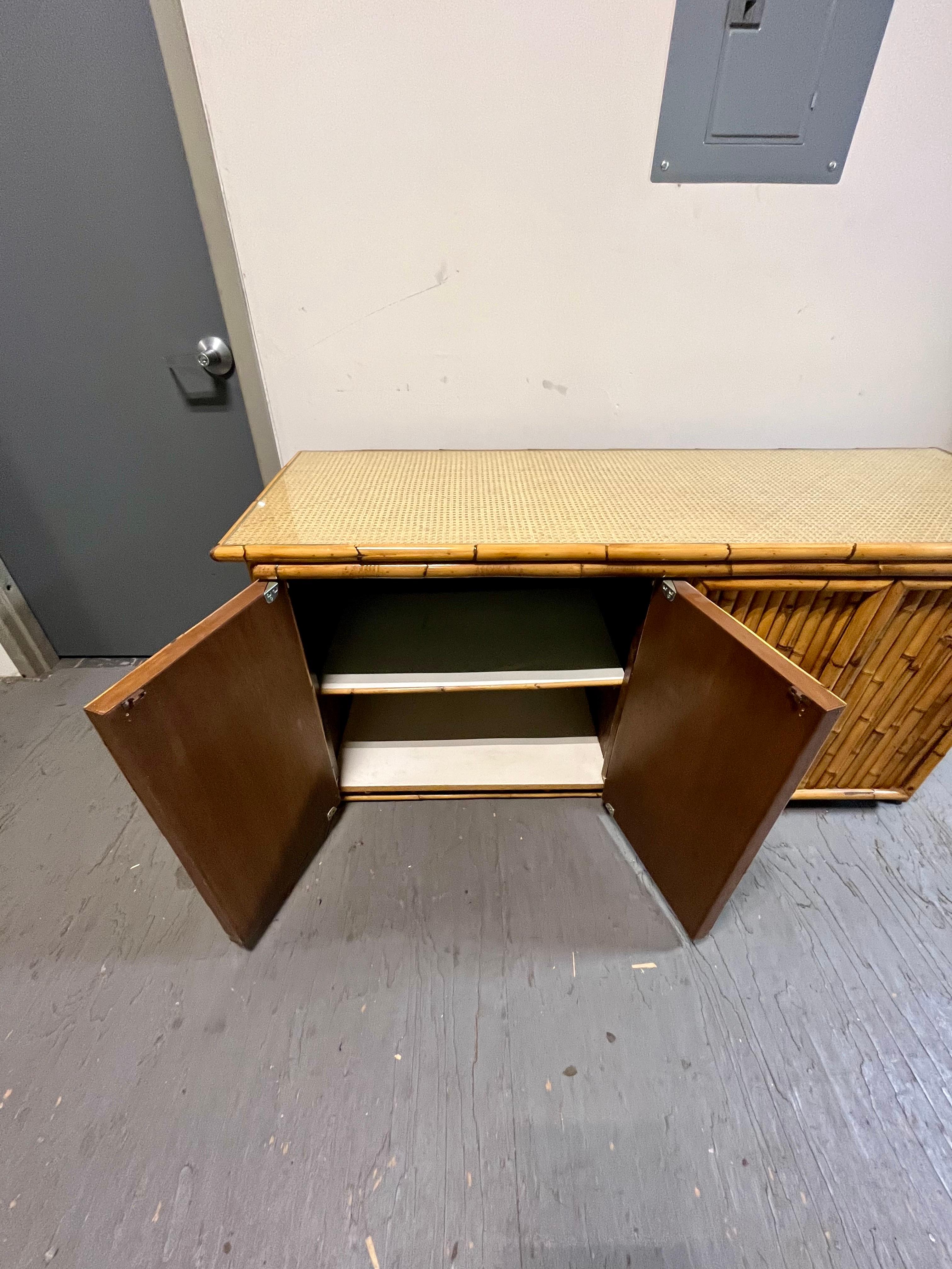 Bellissimo server o buffet in bambù spagnolo, unico e pesante... Costruzione solida. Bambù di grosso calibro con superficie superiore in canna intrecciata sotto vetro. Presenza sostanziale con un ampio spazio di archiviazione. 4 ante rivelano 2