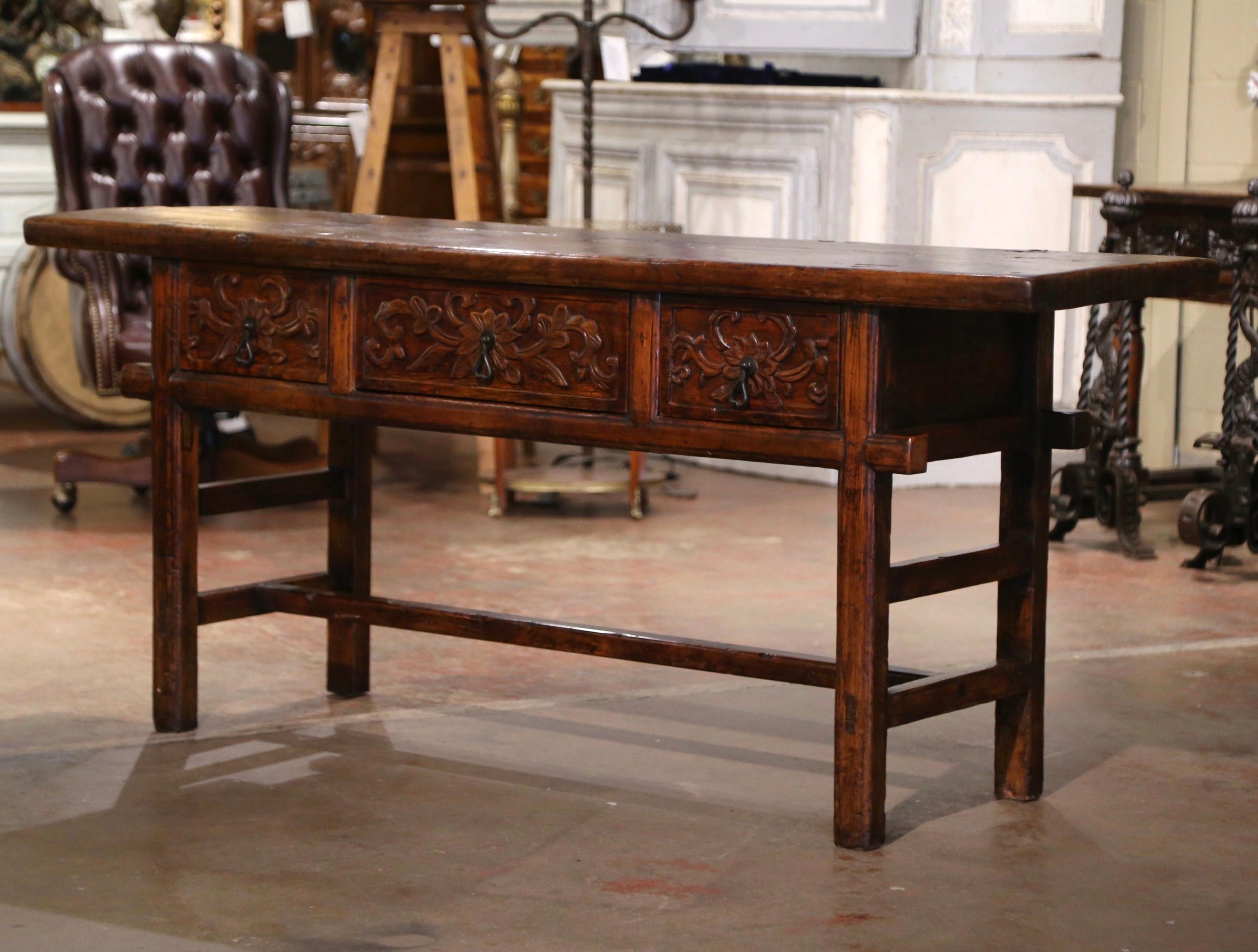 Place this elegant antique console table behind a sofa or against a wall. Crafted in Spain circa 1970 and built of oak and pine, the Baroque sofa table sits on square legs connected with a single bottom stretcher; the table features three hand