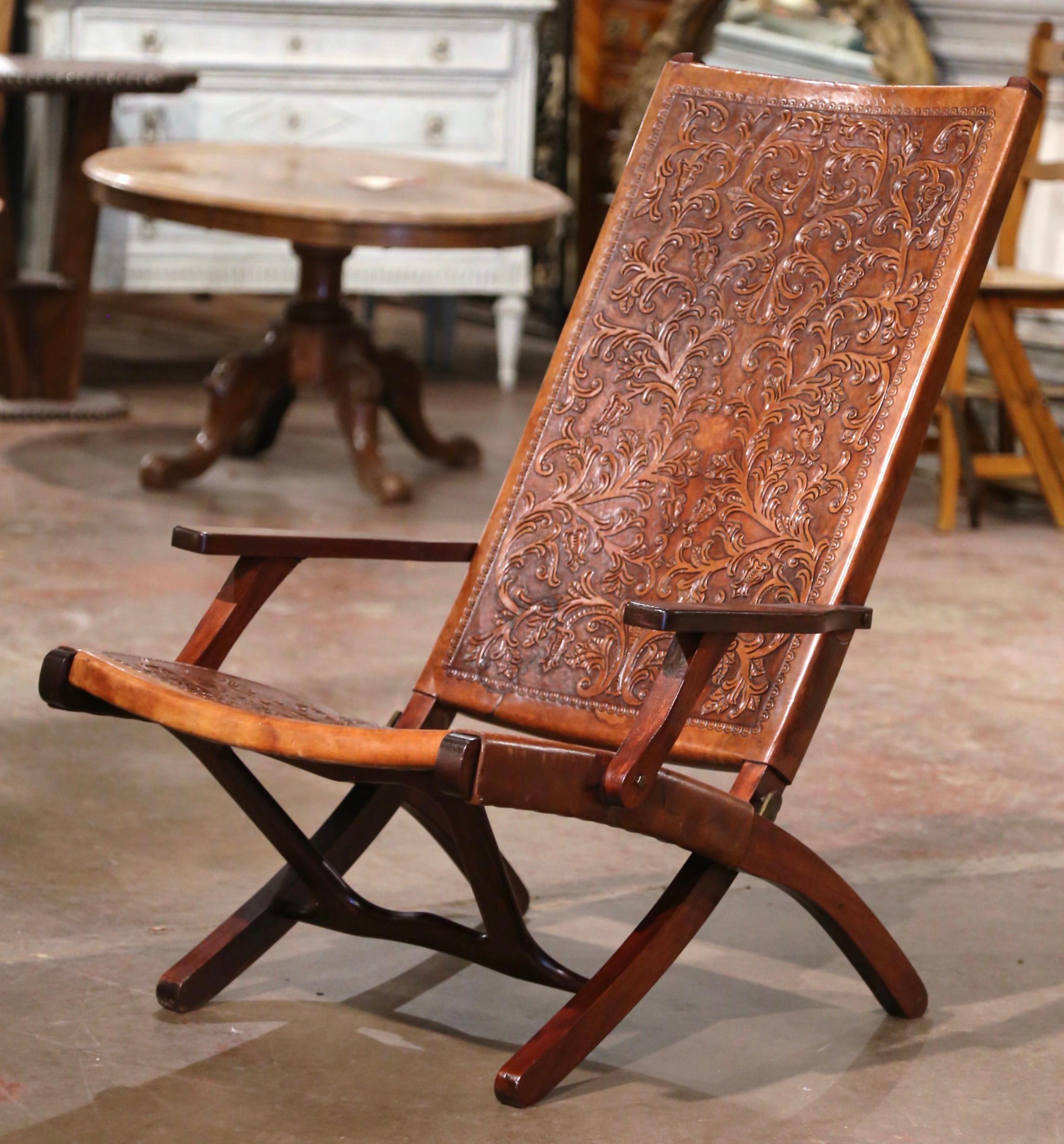 This elegant vintage fruitwood side chair was crafted in Spain, circa 1960. The versatile, folding walnut chair has a simple shape and features its original tooled brown leather seat coverings. The chair is embellished with decorative embossed