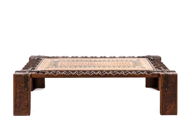 A stunning coffee table made in Solid hand-carved chestnut with a tiled central panel in a geometric pattern. It was made in Spain around 1960. The chestnut wood is carved throughout with geometric patterns and Moorish patterns. Spain was occupied