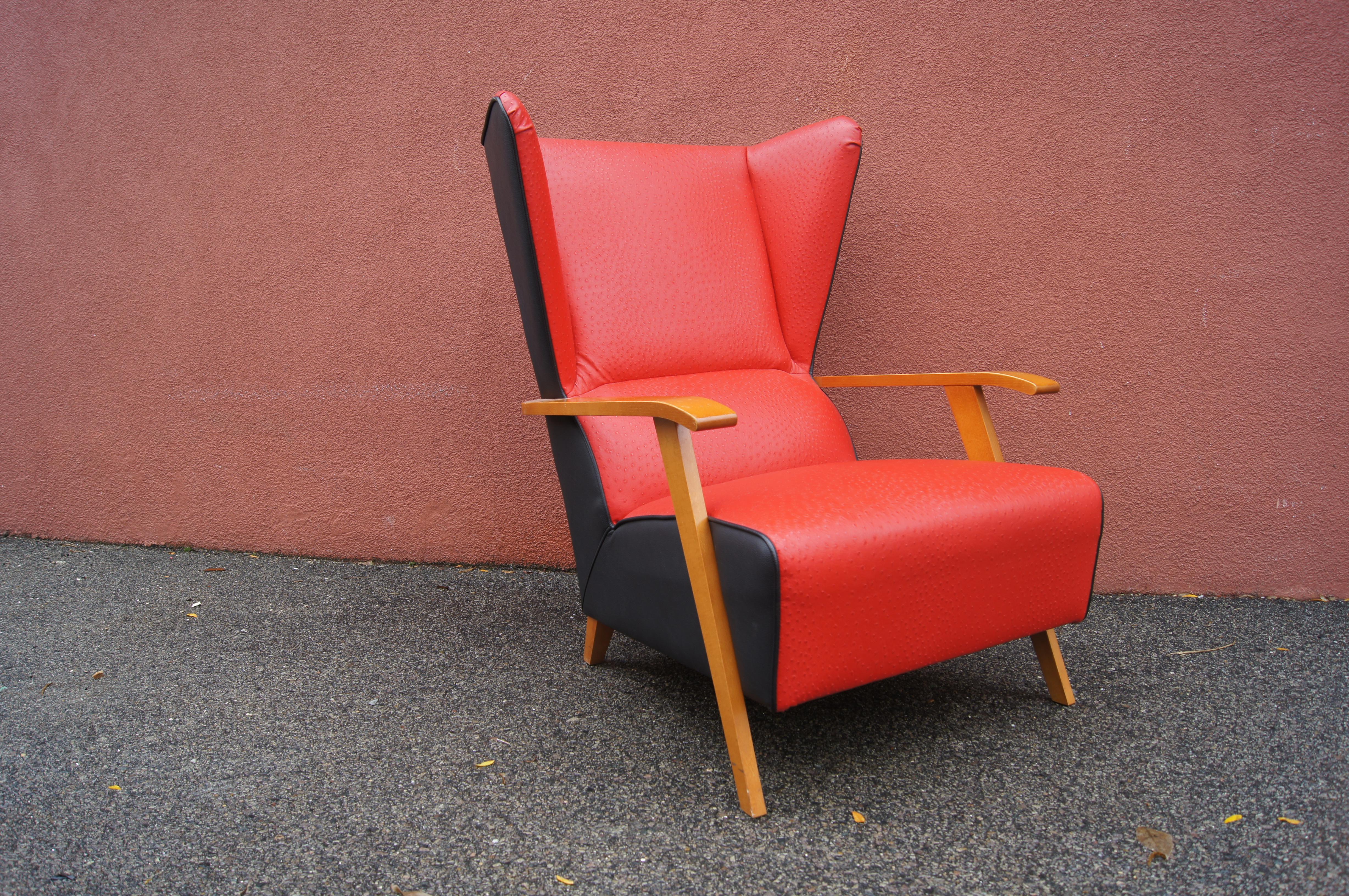 This midcentury Spanish lounge chair features an angular maple frame with a dramatic high back, made more striking by the contrast of ostrich-print red leather in front and black leather in back.