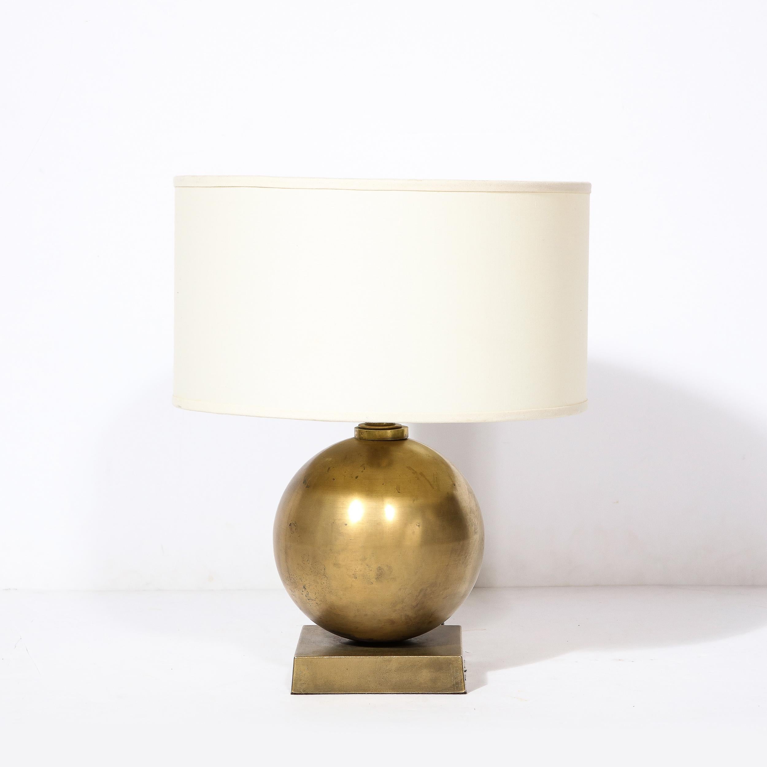 This beautifully minimal Mid-Century Modernist Brass Table Lamp Originates from Italy, Circa 1960. Featuring a beautiful spherical brass body and rectilinear base, the design utilizes minimalist geometric forms to achieve a stunning balance and