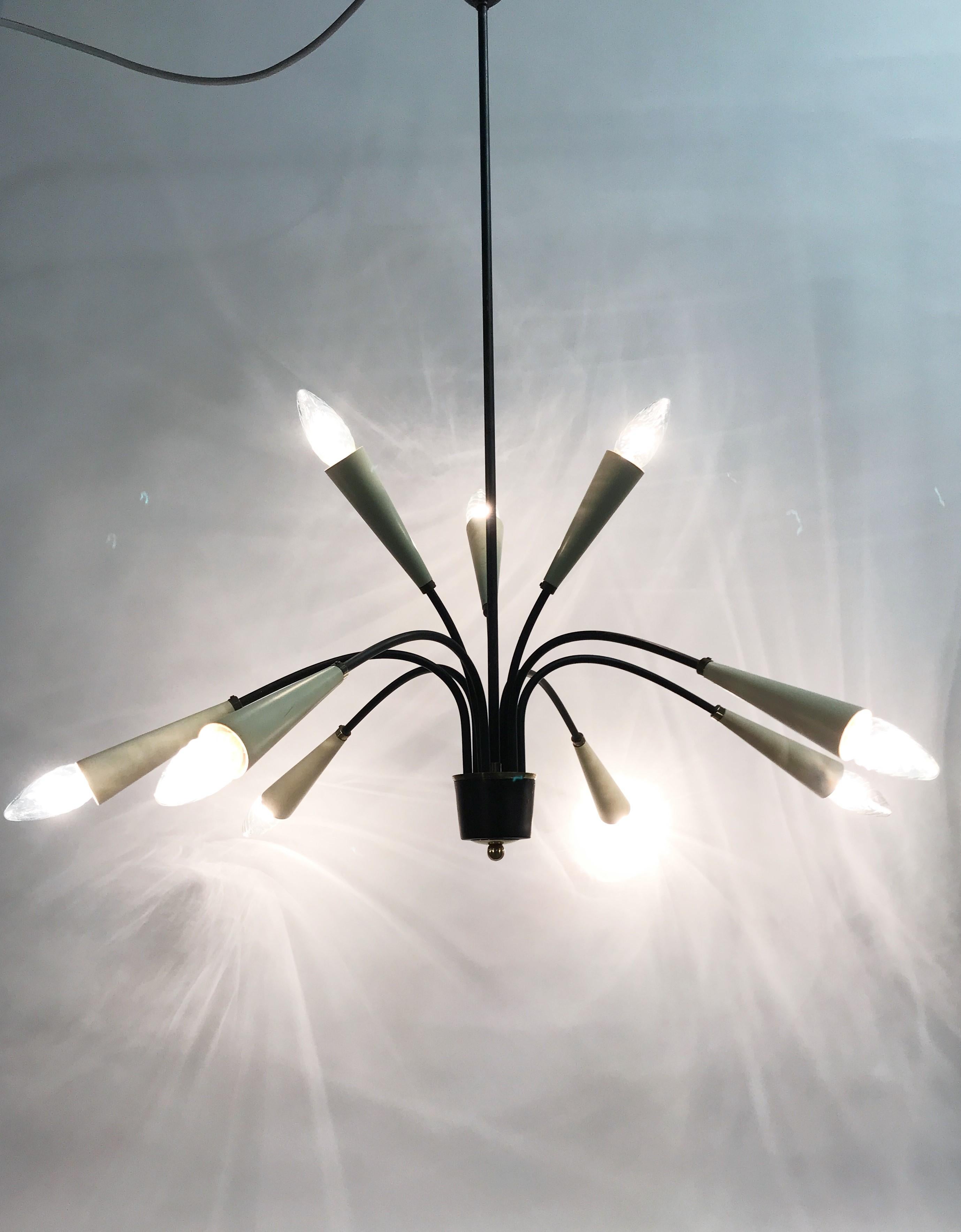 Original midcentury 9 lightpoint spider chandelier.The light fixture has 3 uplighter lightpoints as well.This style is sometimes referred to as rockabilly and was typical for the 1950s and 1960s.Good conditionTested and ready to use with regular E14