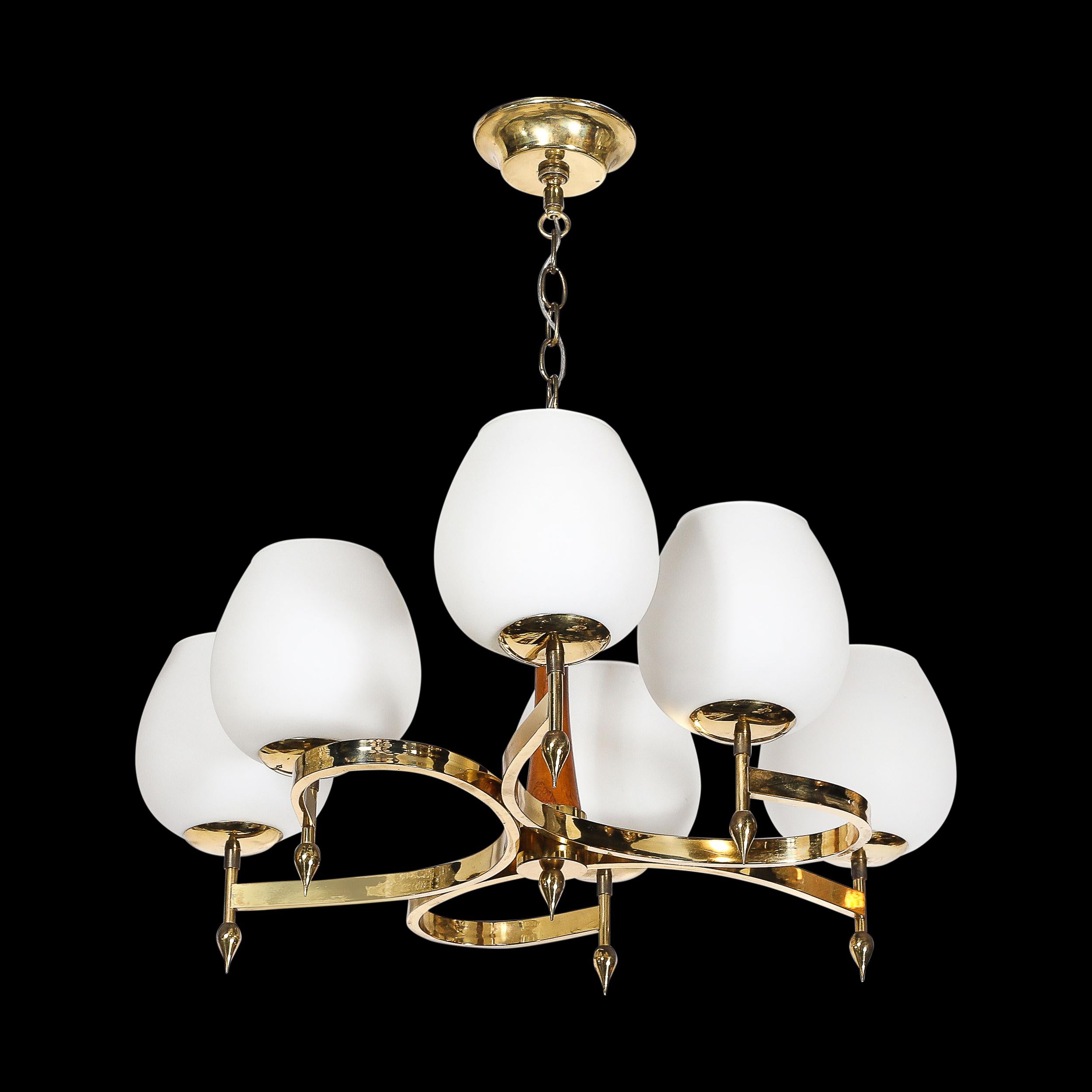 Questo splendido lampadario modernista di metà secolo, risalente al 1950 circa, presenta un dinamico design a spirale con sei bracci elegantemente curvati. Realizzato in Francia, il lampadario combina ricchi accenti di ottone e noce, mostrando