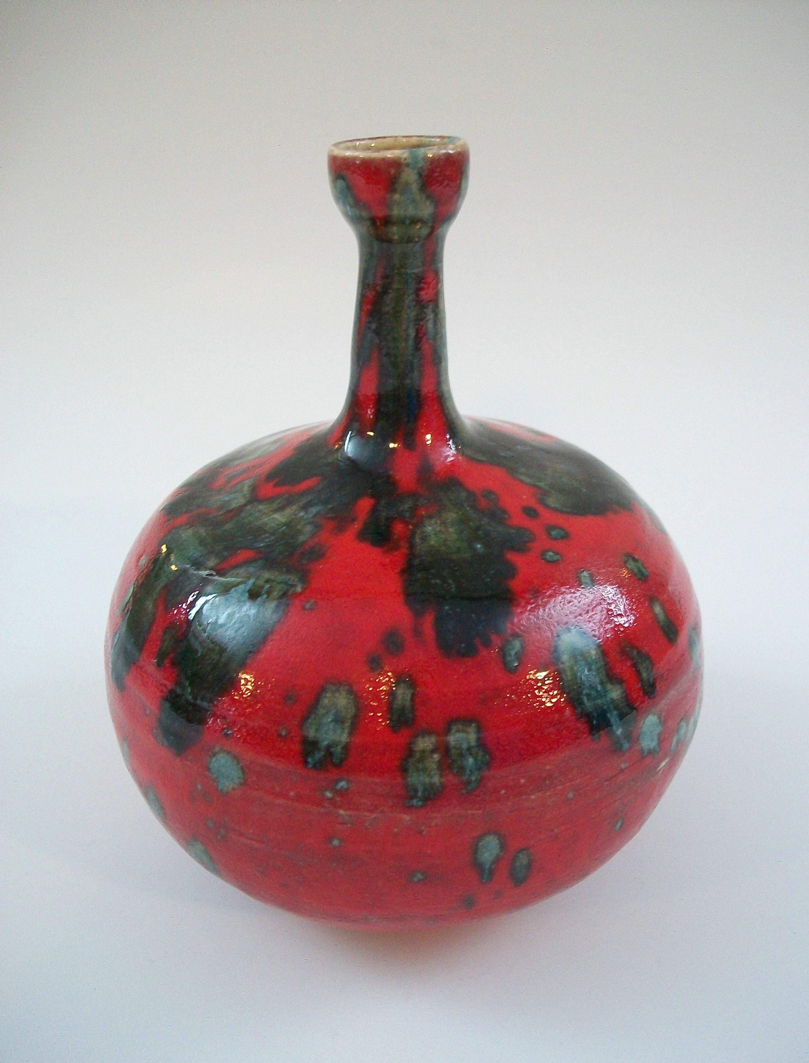 Vaso in Studio Pottery smaltato a spruzzo della metà del secolo scorso - corpo in ceramica color buccia, collo sottile e corpo bulboso - smalto con finitura a buccia d'arancia - base non smaltata - firmato sulla base SE (autore