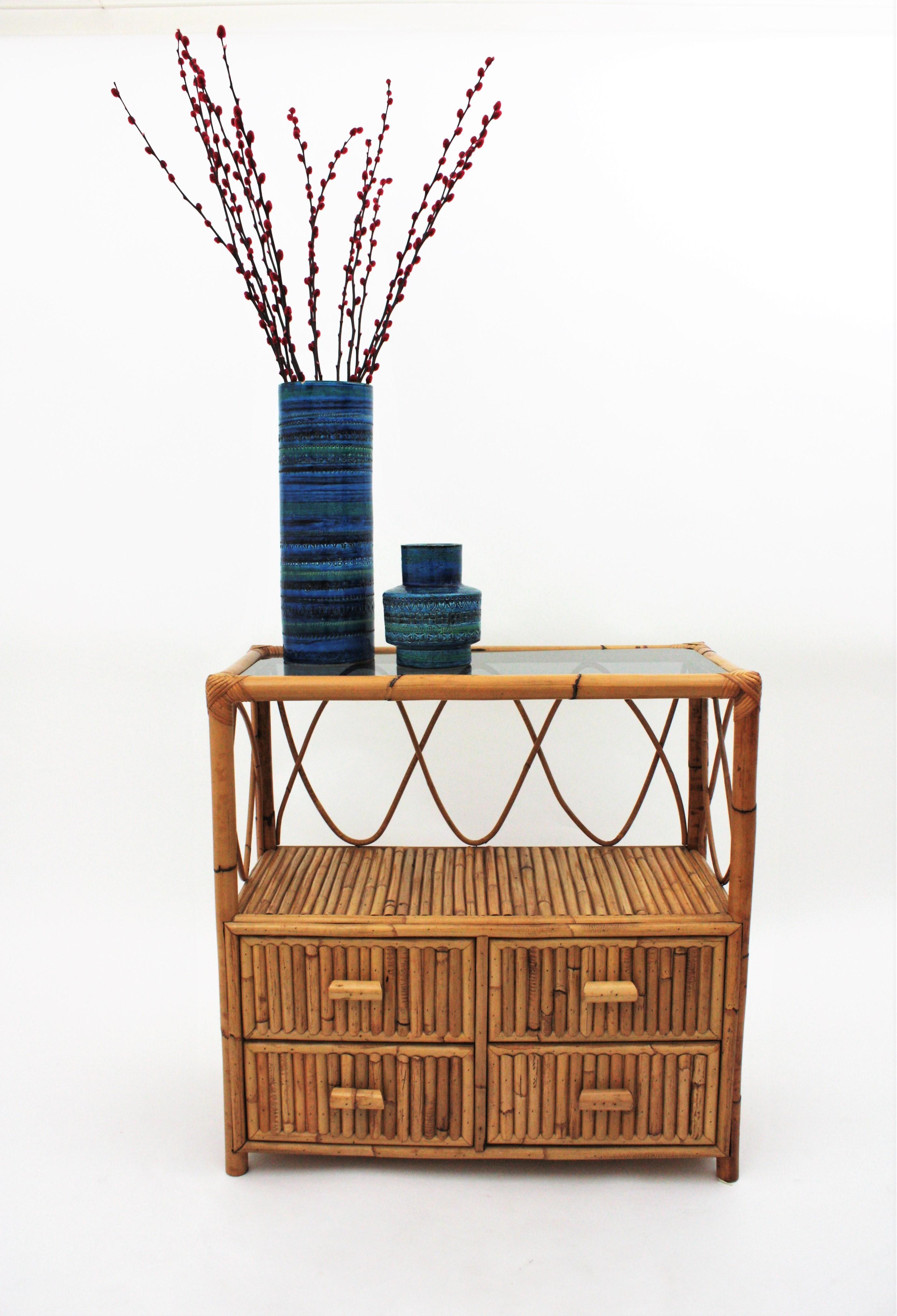 Vintage split reed / rattan and bamboo console table with four drawers and glass top. Italy, 1960s.
4 Drawers and one shelf than can be used as book or magazine stand.
Rattan drawer pulls and smoked glass surface on the top.
It will be a nice