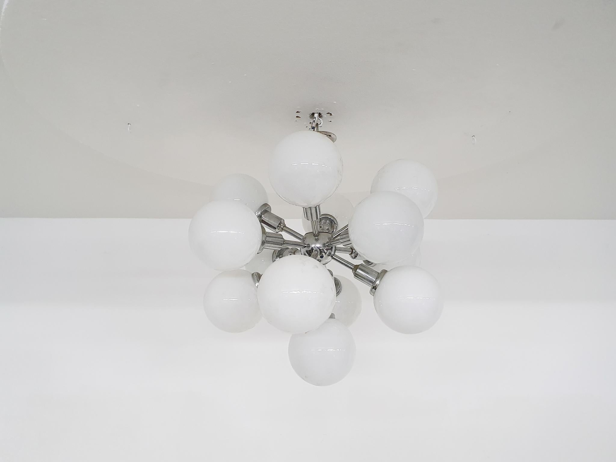 Silver metal pendant light with 13 white glass globes. The globes have a diameter of each 12 cm. The light needs 13x E14 light bulbs.