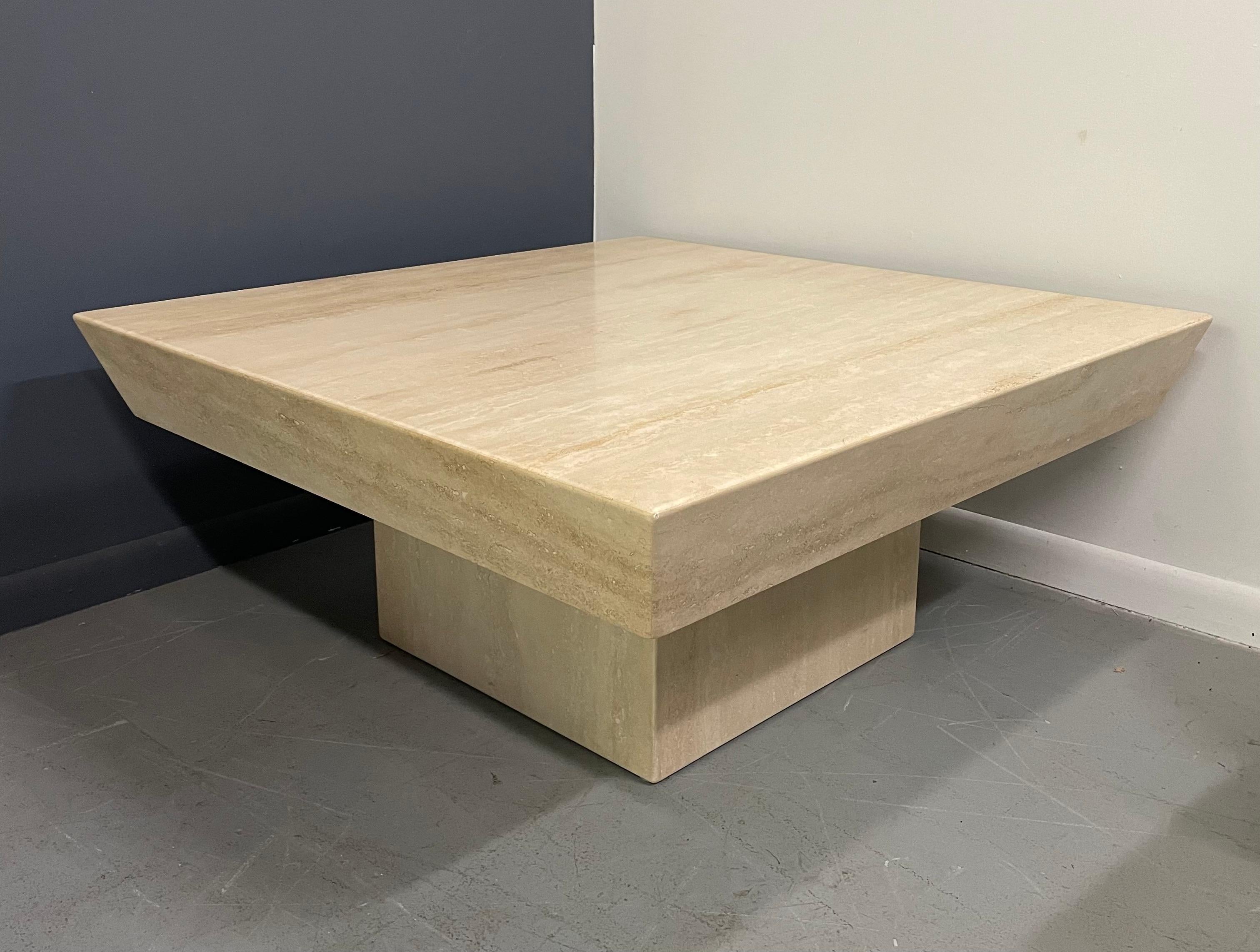 Impressive travertine table top with deep angled sides that provide a profile that makes for a one of a kind look.