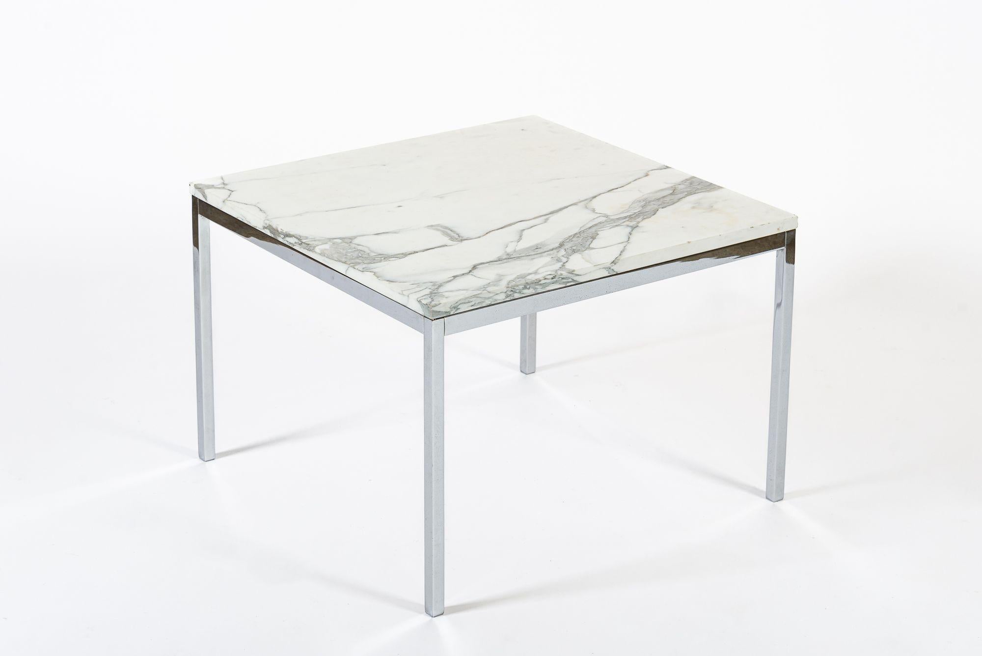 This vintage mid century modern square white marble side table or coffee table designed by Florence Knoll is circa 1960. The table is well-constructed of high-quality materials featuring a square, white marble tabletop that rests on a chrome-plated