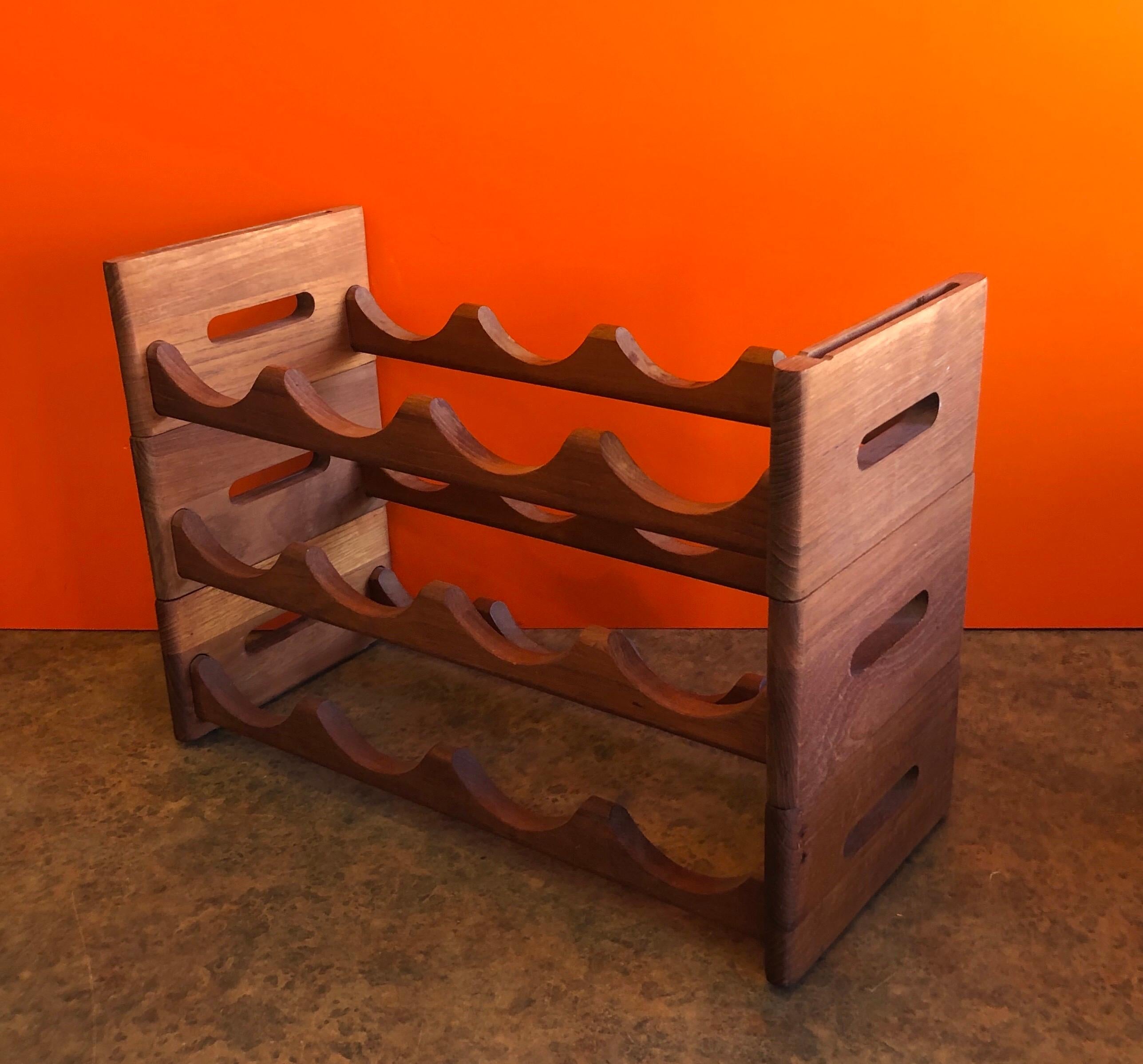 Midcentury stackable solid teak wine rack by Kalmar Designs, circa 1970s. This 3 piece rack can hold up to 12 bottles and is in very good vintage condition. #1085.