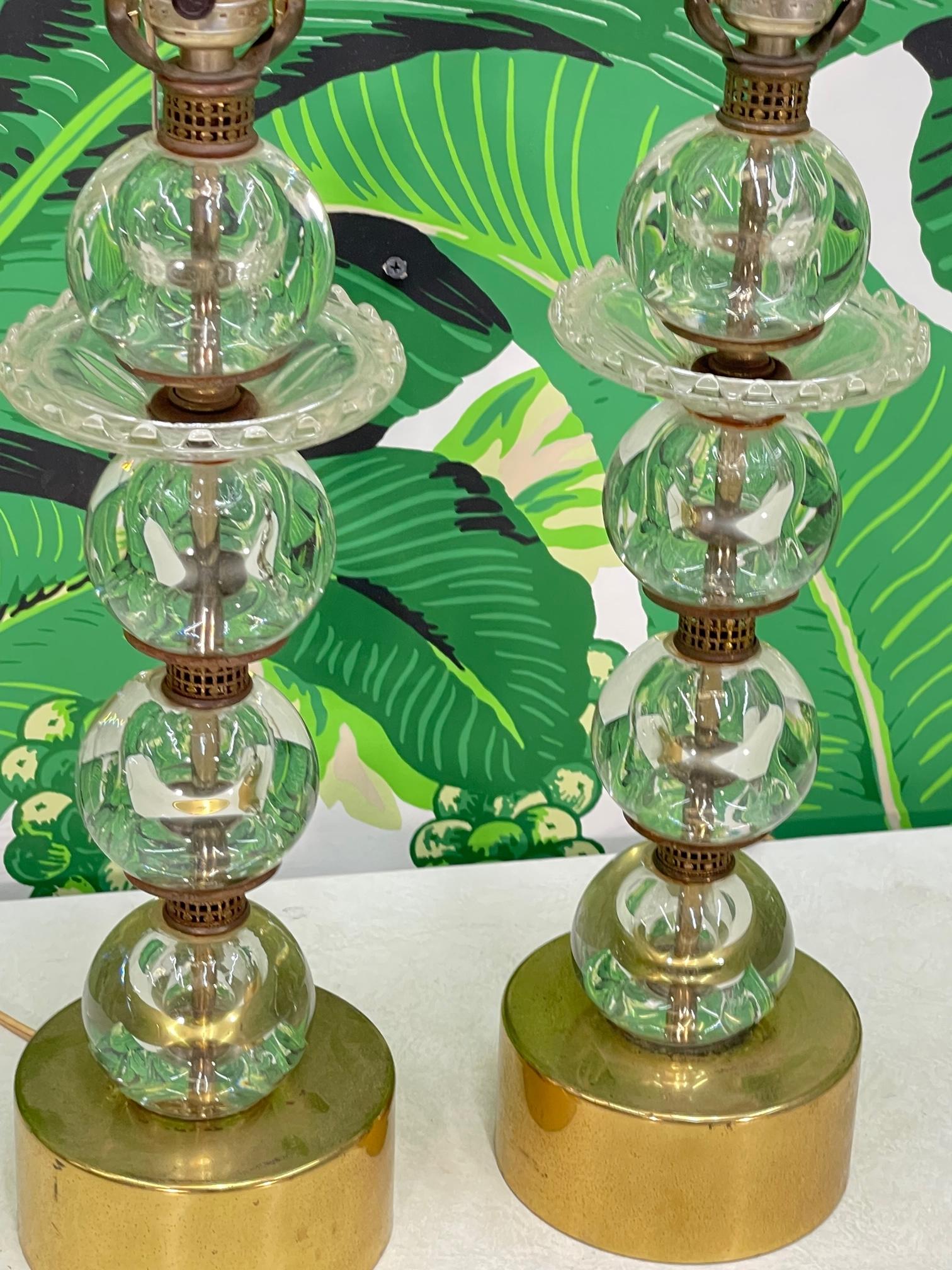 Pair of mid century table lamps feature glass spheres stacked with brass detailing and a brass base. Good condition with imperfections consistent with age, see photos for condition details. 
For a shipping quote to your exact zip code, please