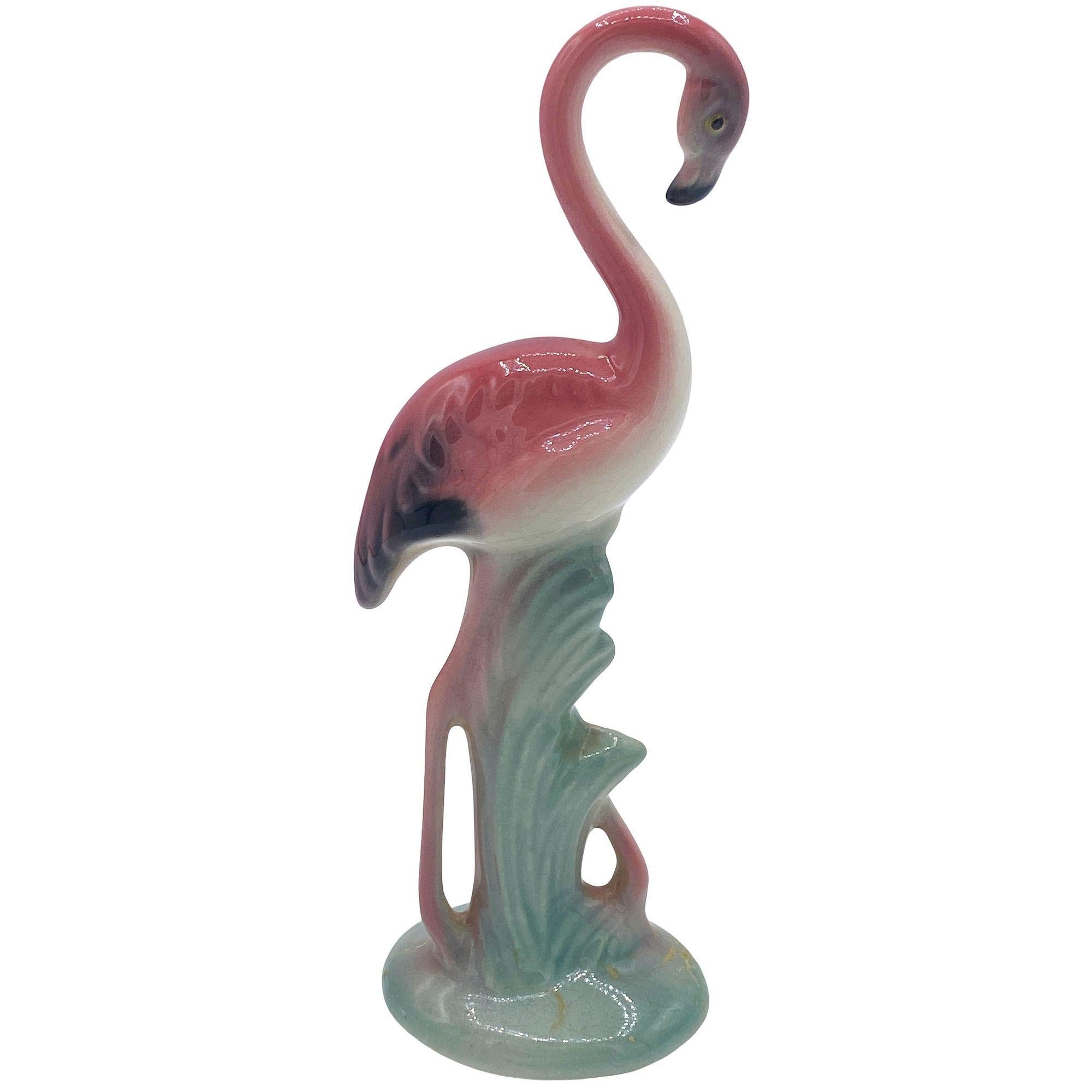 Mid-century pink and green ceramic flamingo tabletop statue by Brad Keeler. It features a beautifully detailed pink flamingo in lush leaves and grass. The flamingo with a gloss finish that highlights the rich pinks, greens, and black accents.

Brad