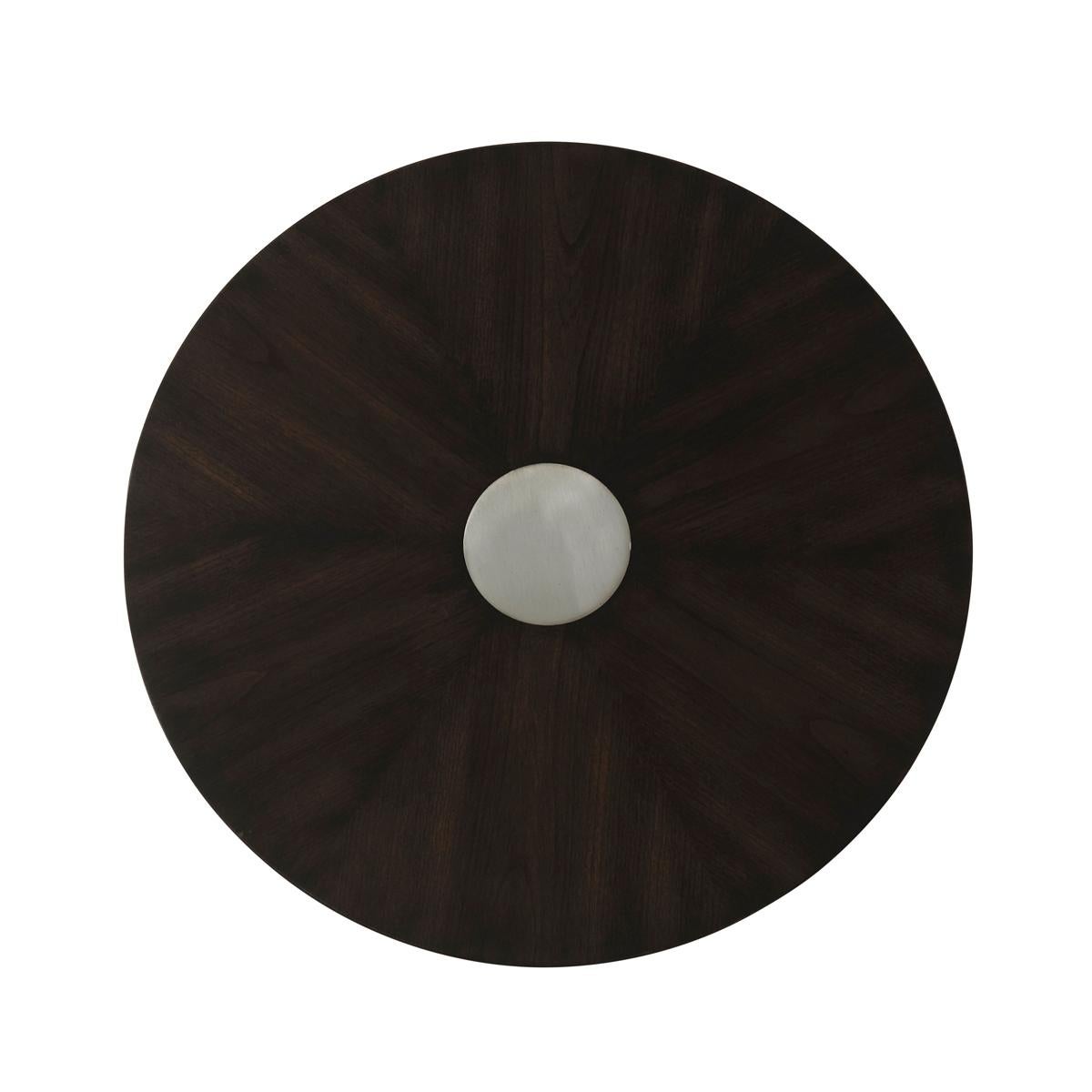 In the dark Ossian finish to the starburst cherry veneered top with a central metal inlaid decorative dic. Raised on a tapered column pedestal wrapped in a grey leather detail.

Dimensions: 20