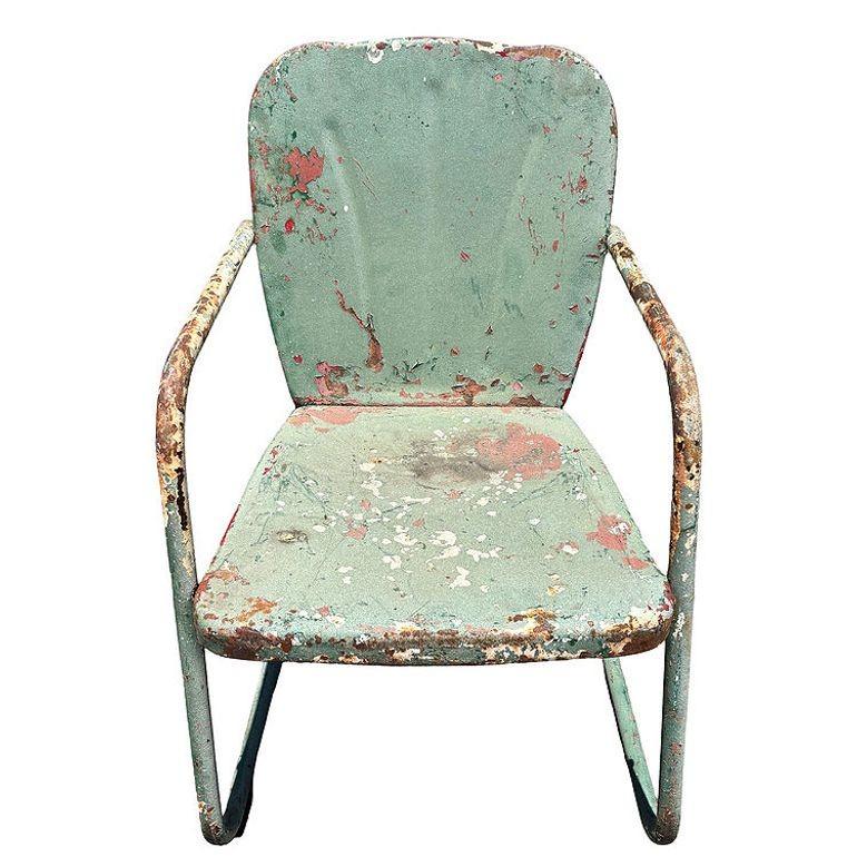 Steel Mid-century Springer Outdoor green enamel Lounge Chair. The chair features a round tubular U-shaped base that rocks and forth when pushed back and forth. The chair features a Shellback pressed steel seat back with a lined pattern in the