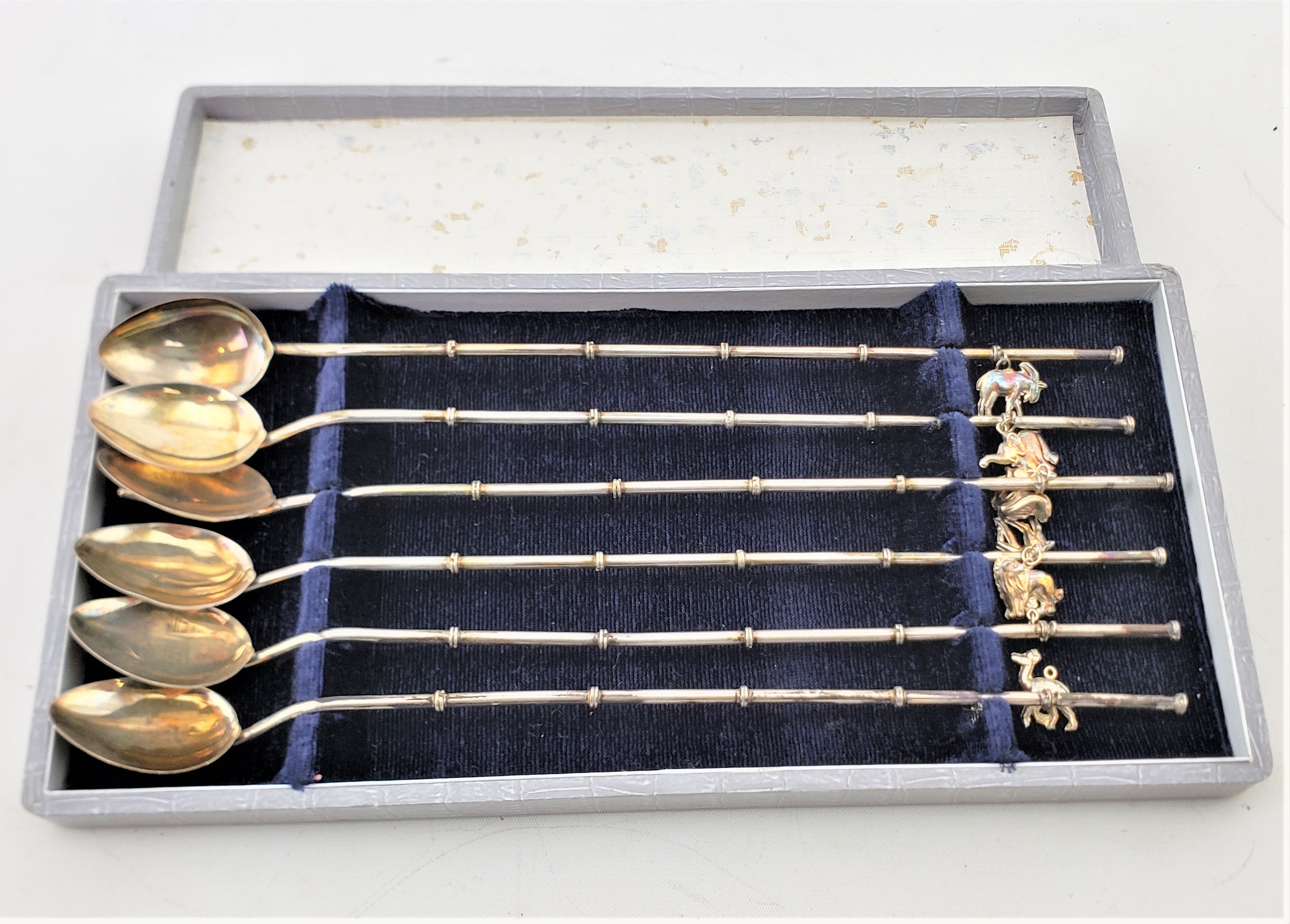 This boxed set of six sipping straw cocktail or ice tea spoons are unsigned, but presumed to have originated from Germany and date to approximately 1960 and done in the period Mid-Century Modern style. The spoons are composed of a combination of