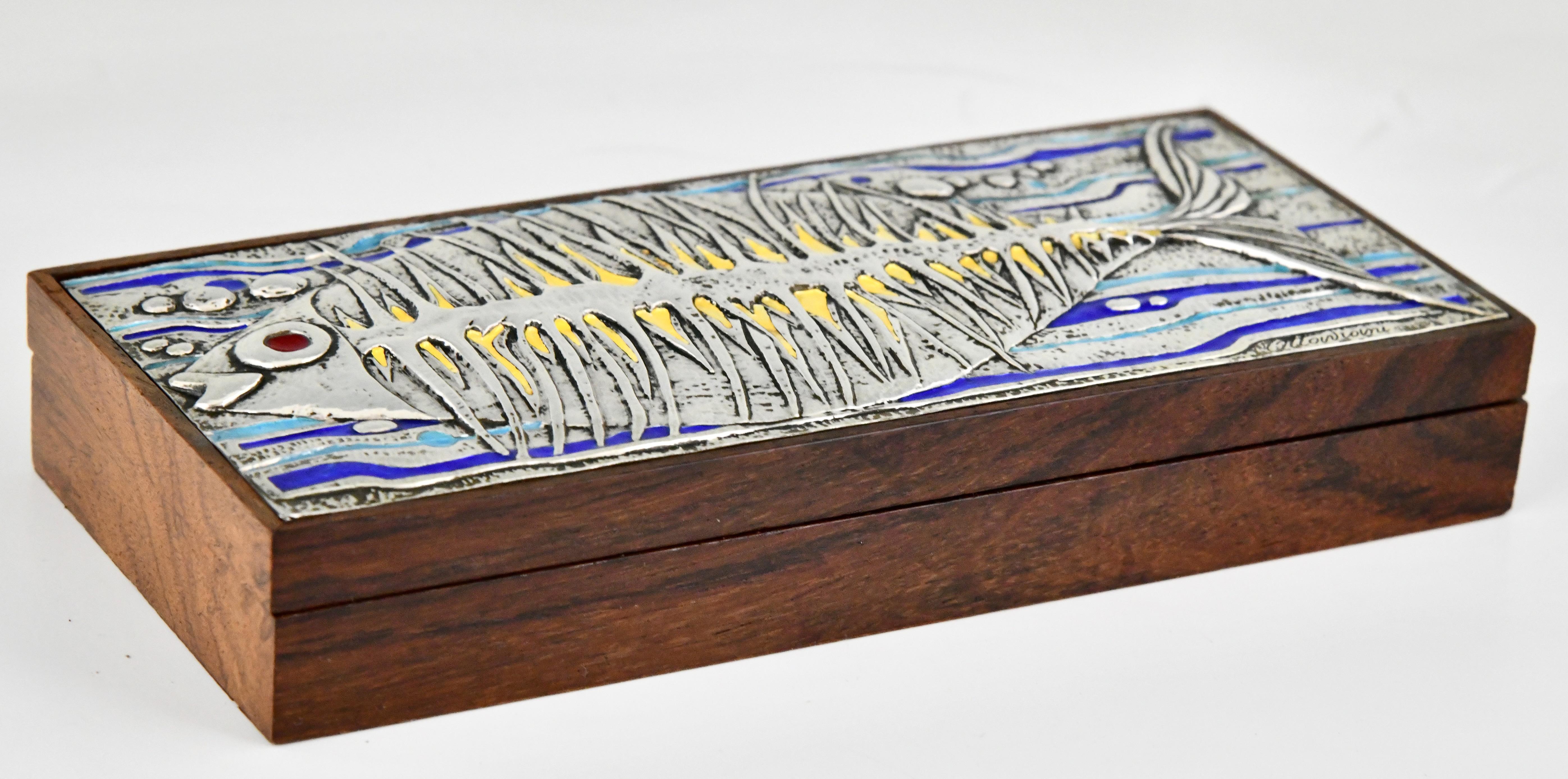 Mid Century Sterling Silver and enamel box with fish signed by Ottaviani.
Marked, Italy, Ca. 1960.
Blue, yellow and turquoise enamel.
Ottaviani (1945) is a jewelry and silver firm located in the small seaside town of Recanati, Italy. They had a