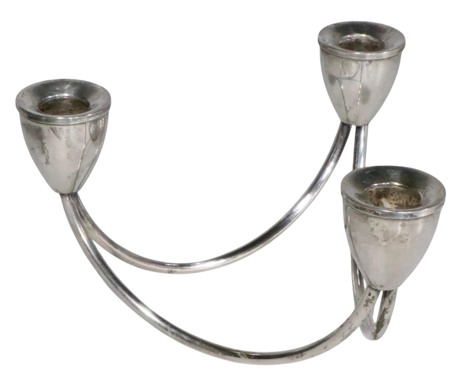 Elegante candelabro a tre bracci in argento sterling di metà secolo di Maurice Duchin ( Duchin Creation ). Il candeliere è caratterizzato da una graziosa struttura a Looping che sostiene  le tre tazze di candele. Questo esemplare è in ottime