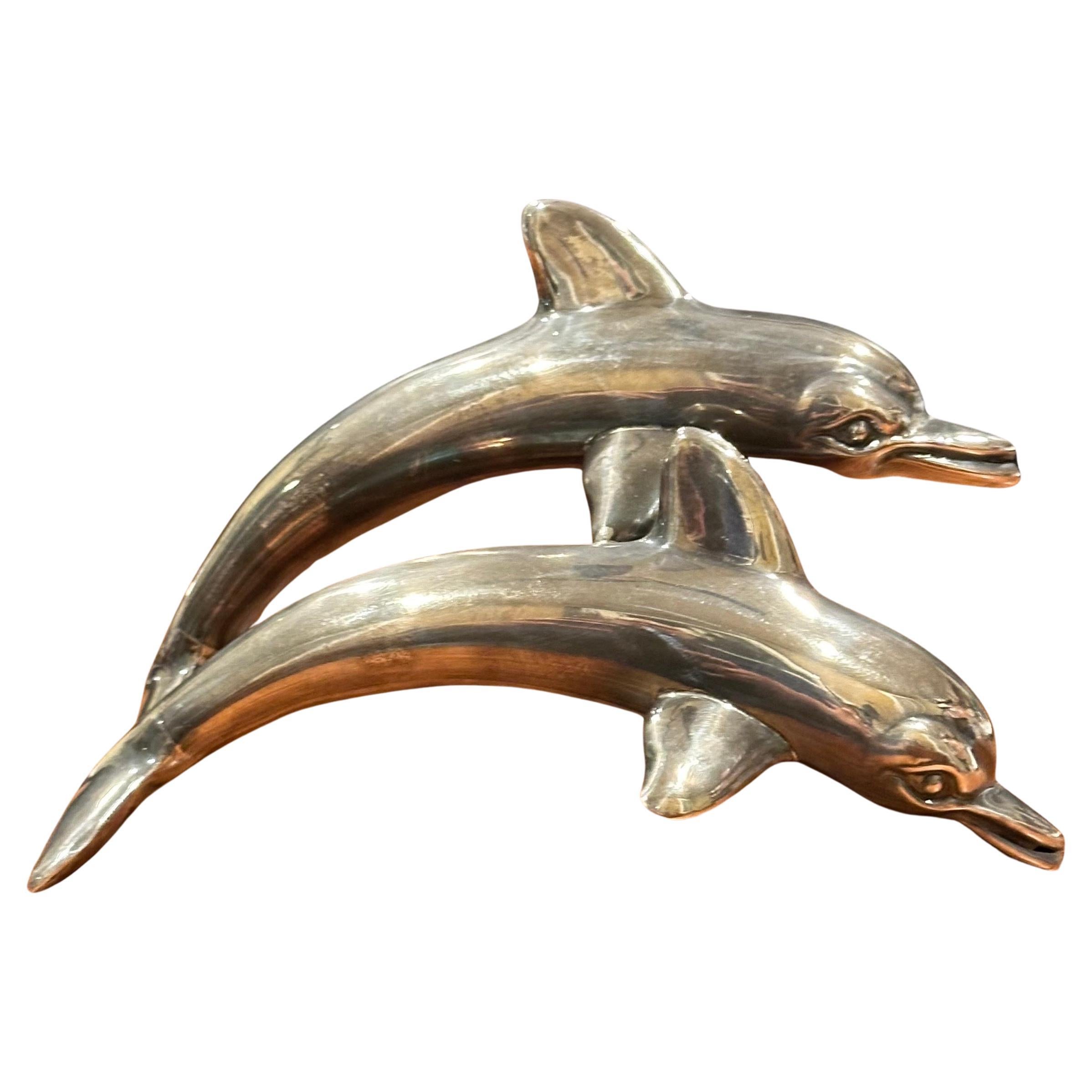 Très belle sculpture en argent sterling à deux dauphins, datant du milieu du siècle dernier, vers les années 1970. La pièce est en très bon état avec une belle patine et mesure 7 